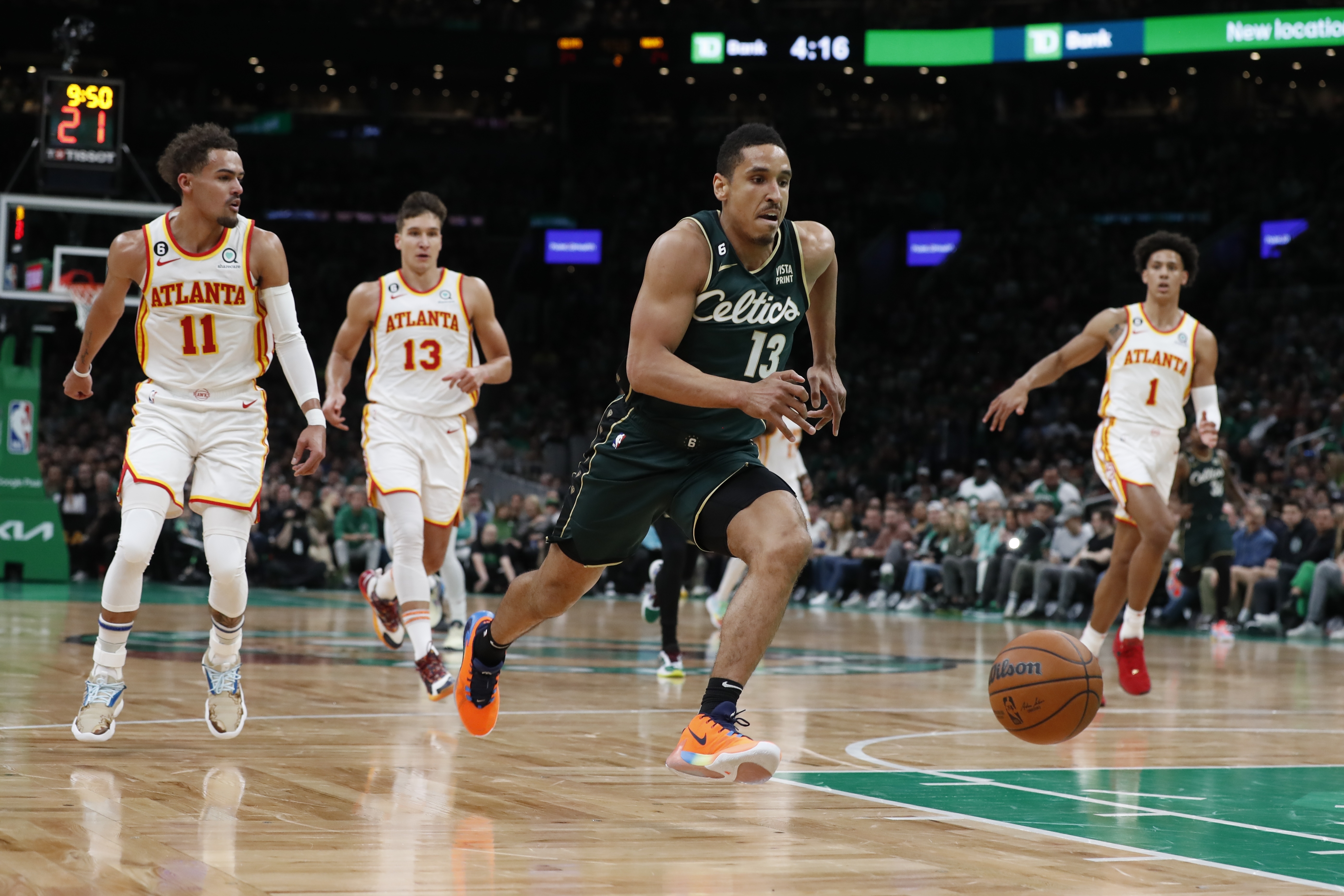 Boston Celtics' Malcolm Brogdon, center, chases down a loose ball in front of Atlanta Hawks' Trae Young (11), Bogdan Bogdanovic (13), and Jalen Johnson (1) in the first half during Game 1 in the first round of the NBA basketball playoffs, Saturday, April 15, 2023, in Boston.