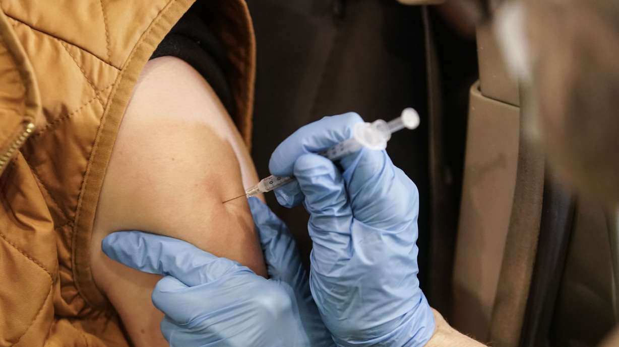 Jaynie Murdock receives her booster shot at a drive-thru vaccination clinic at the Legacy Events Center in Farmington on Jan. 24, 2022. Utah health care providers are being told to get rid of any of the original COVID-19 vaccine doses from Pfizer and Moderna they still have in stock.