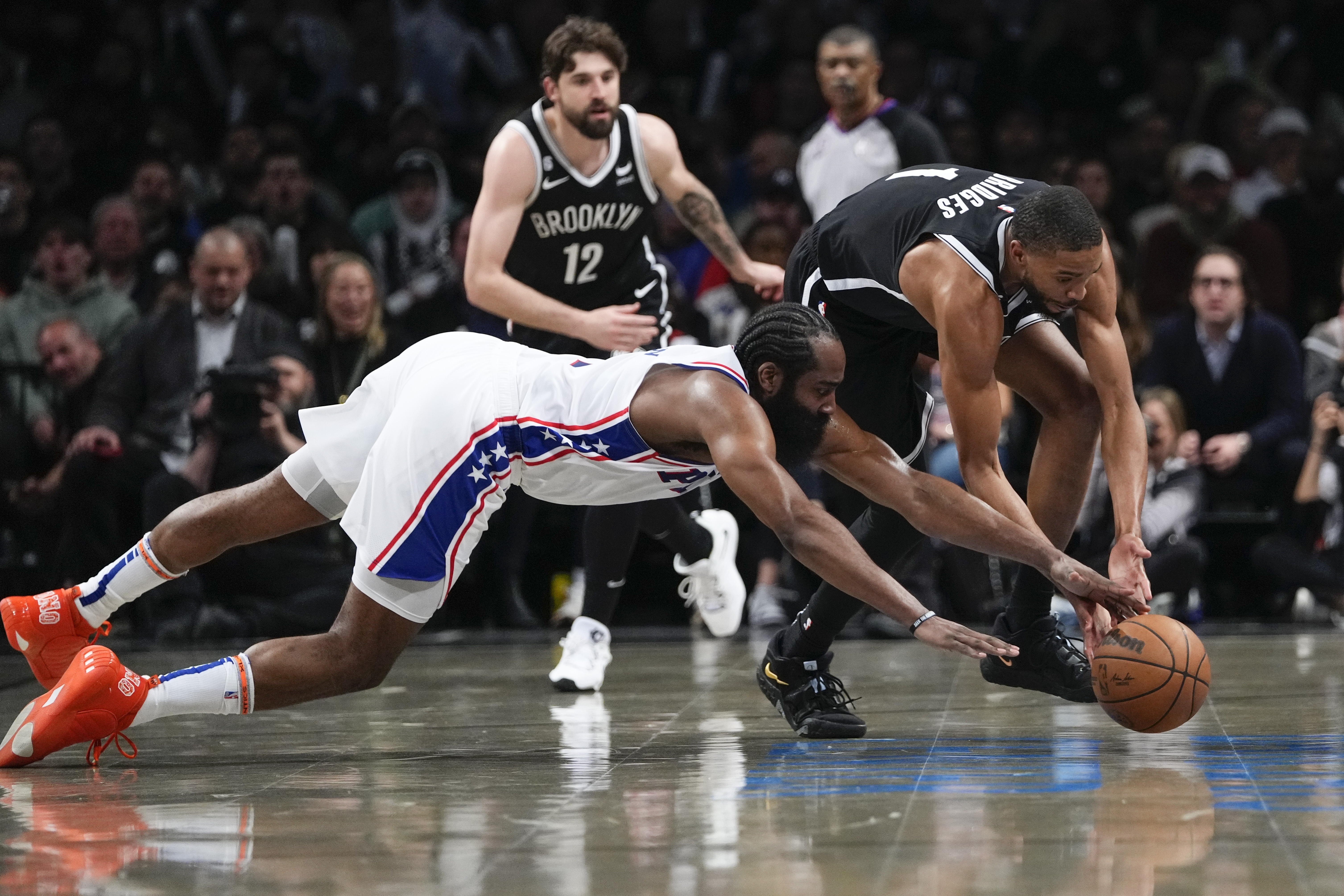 Philadelphia 76ers' James Harden, left, and Brooklyn Nets' Mikal Bridges scramble for the ball during the second half in Game 3 of an NBA basketball first-round playoff series Thursday, April 20, 2023, in New York. 