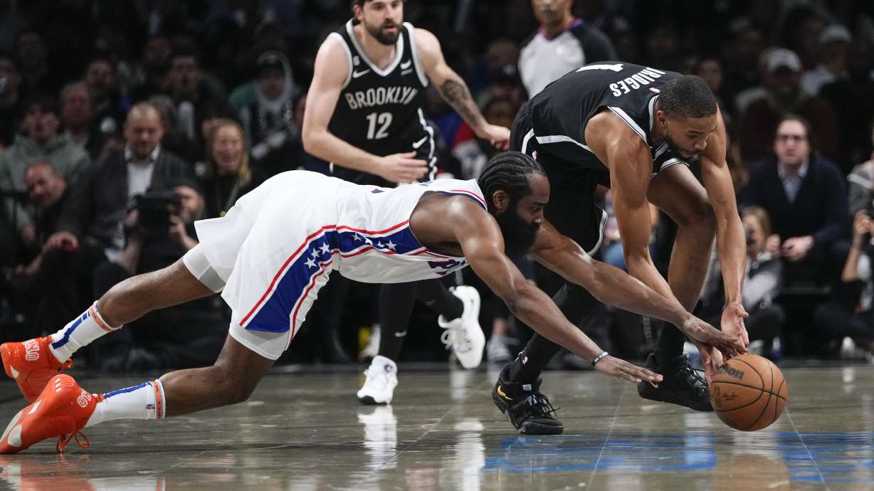 Philadelphia 76ers' James Harden, left, and Brooklyn Nets' Mikal Bridges scramble for the ball during the second half in Game 3 of an NBA basketball first-round playoff series Thursday, April 20, 2023, in New York.