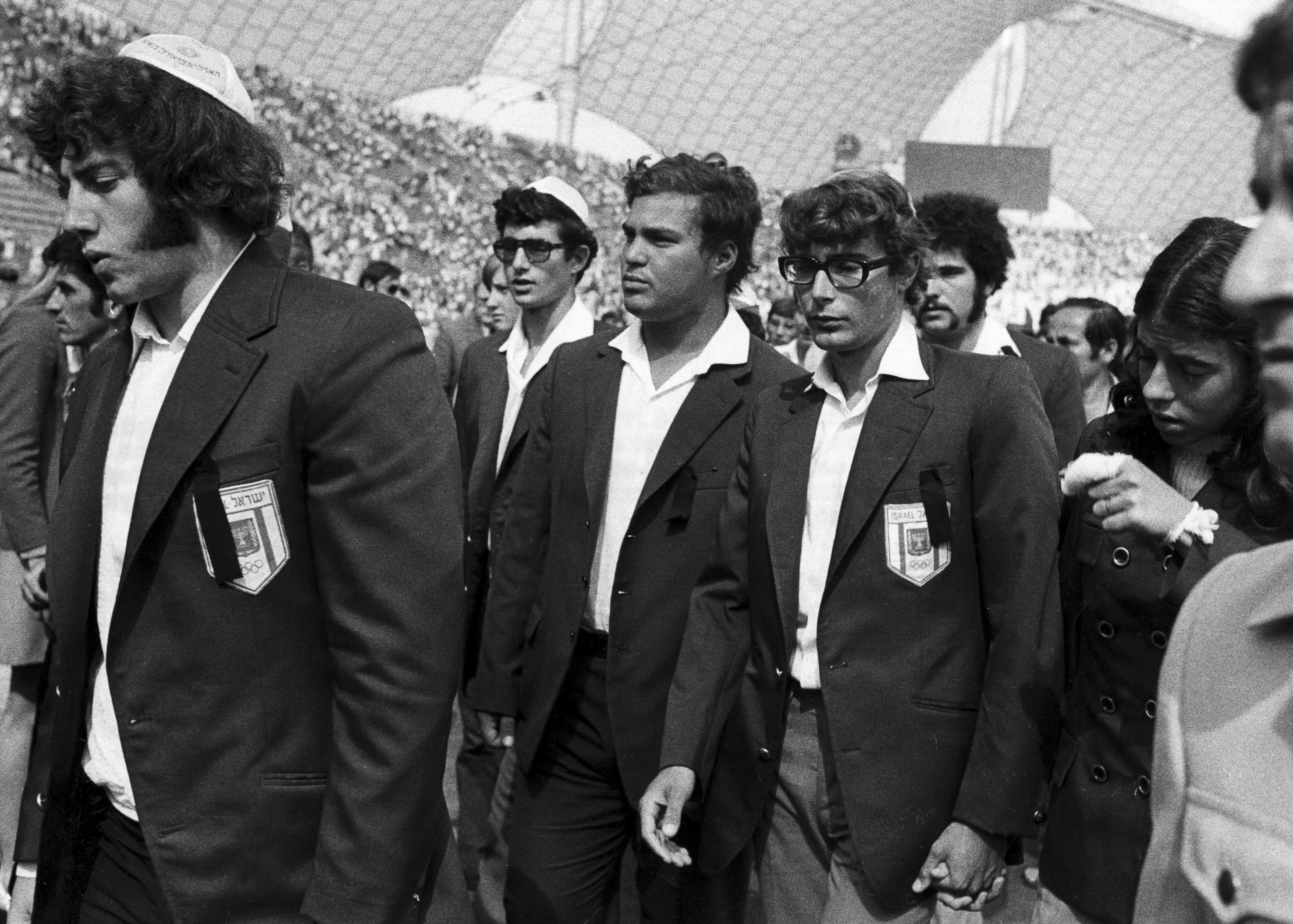 FILE - Members of Israel's Olympic team place black ribbons in their pockets after a memorial service mourning their comrades killed in Tuesday's Arab terrorists attack and subsequent police shoot-out leave the Olympic stadium in Munich, then West Germany, Wednesday, Sept. 6, 1972. The German government said Friday, April 21, 2023 it has set up an international commission of experts to review the events surrounding the 1972 attack on the Munich Olympics, a panel that was part of an agreement reached last year with relatives of the 11 Israeli athletes who were killed by Palestinian militants. 