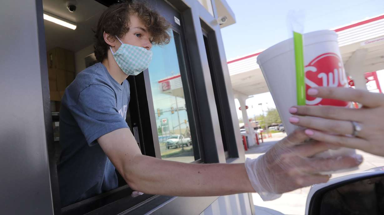 Henry Randle works at Swig’s drive-thru window in Millcreek on June 3, 2020. On Wednesday, the Sugar House store was named in a lawsuit from a neighboring laundromat claiming its two-lane drive-thru breaches a 20-year-old contract.