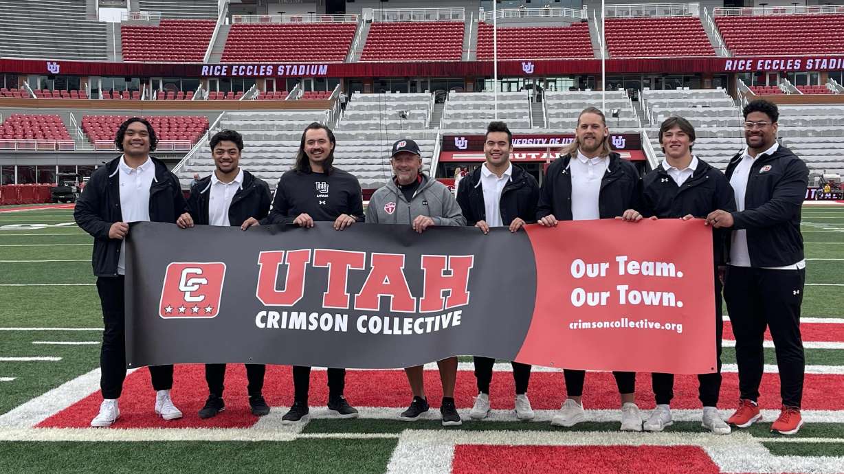 Utah football head coach Kyle Whittingham poses with his players at Rice-Eccles Stadium as part of the Utah Crimson Collective announcement on April 21, 2023.