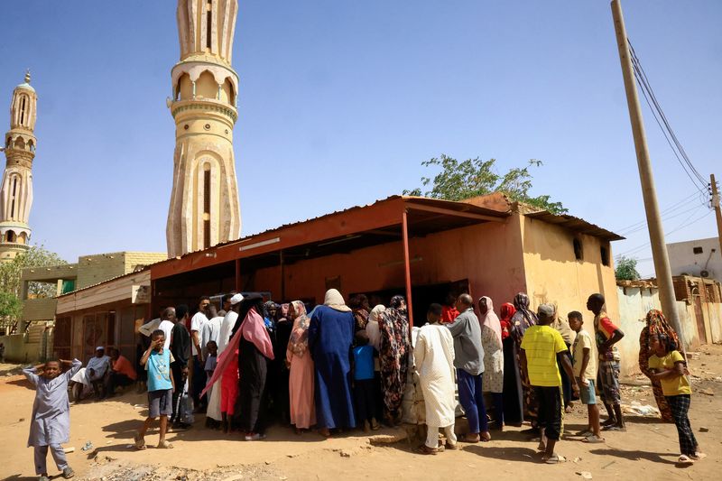 People gather to get bread during clashes between the paramilitary Rapid Support Forces and the army in Khartoum North, Sudan, Saturday. The U.S. military evacuated American government personnel from Khartoum, President Joe Biden said on Saturday,