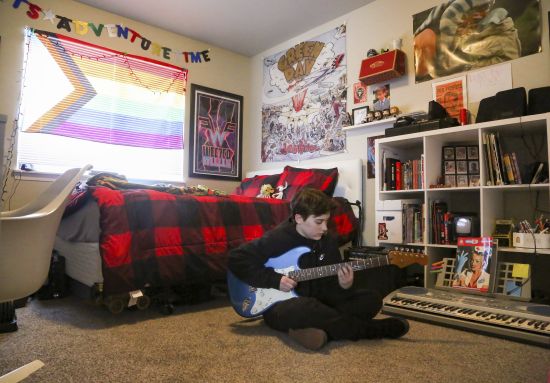 Asher Wilcox-Broekemeier, 13, practices guitar in his bedroom March 27 in Sioux Falls, S.D. When Asher began menstruating, he felt a terrifying disconnect between how his body was changing on the outside and how he felt inside. His mom began researching online to understand what was going on with her son, while Asher’s father, Brian, looked to doctors for expertise. With referrals from his longtime pediatrician, Asher met with therapists and doctors who helped explore his history, personality and feelings over his whole life.