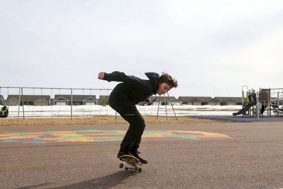 Asher Wilcox-Broekemeier, 13, practices with his skateboard at an elementary school playground after school hours on March 27 in Sioux Falls, S.D. Asher's parents have noticed his emotions stabilize through his treatment. “From a parent’s view, I see him as being able to be himself authentically, which is wonderful for him,” Elizabeth said.