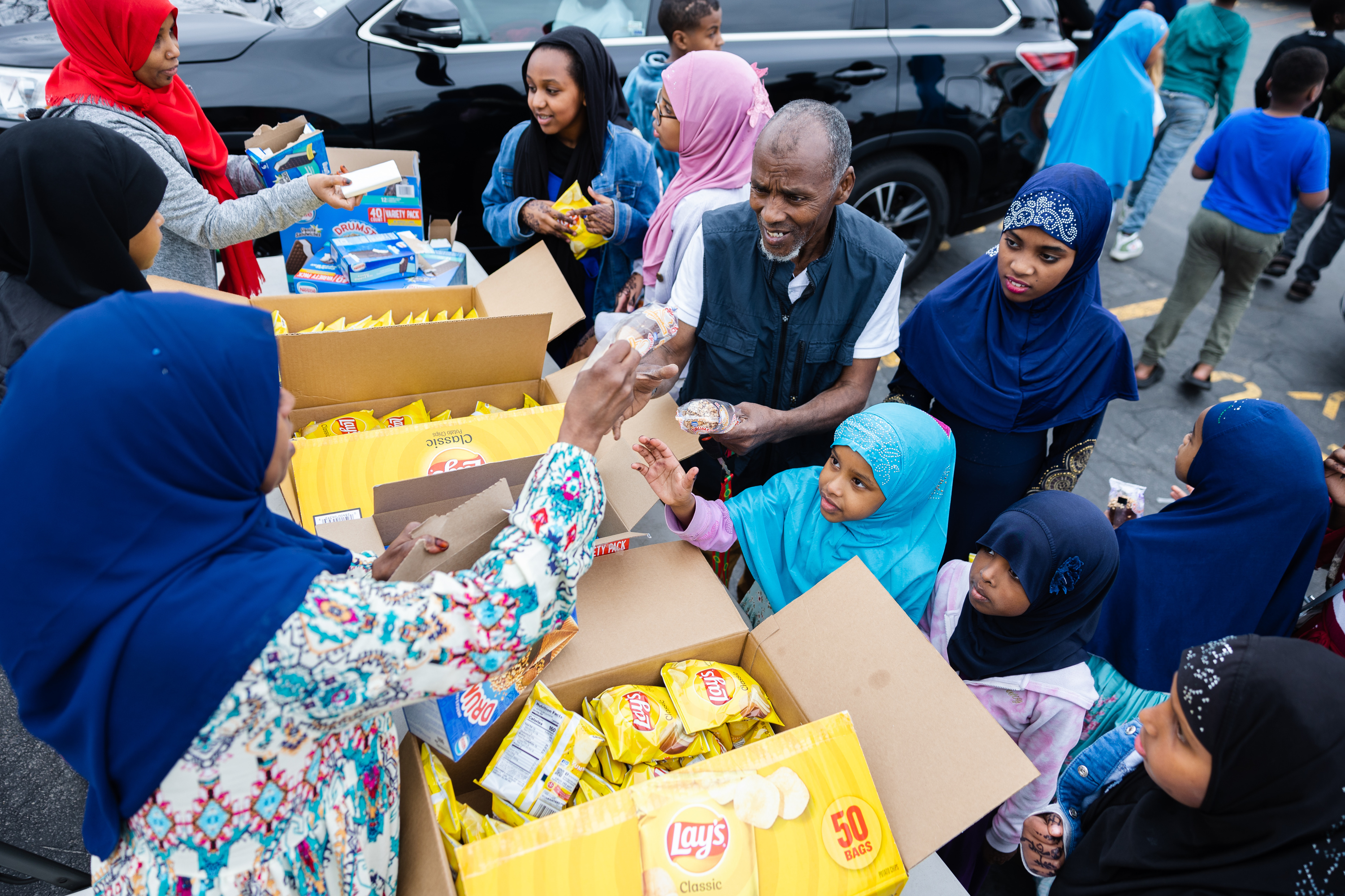 Volunteers hand out snacks during the Eid al-Fitr celebration at Hartland Partnership Center in Salt Lake City on Saturday.