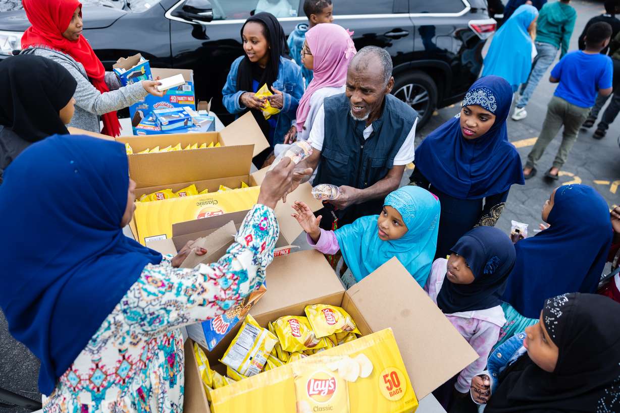 Volunteers hand out snacks during the Eid al-Fitr celebration at Hartland Partnership Center in Salt Lake City on Saturday.