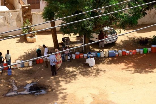 People wait to get water during clashes between the paramilitary Rapid Support Forces and the army in Khartoum North, Sudan, Saturday.