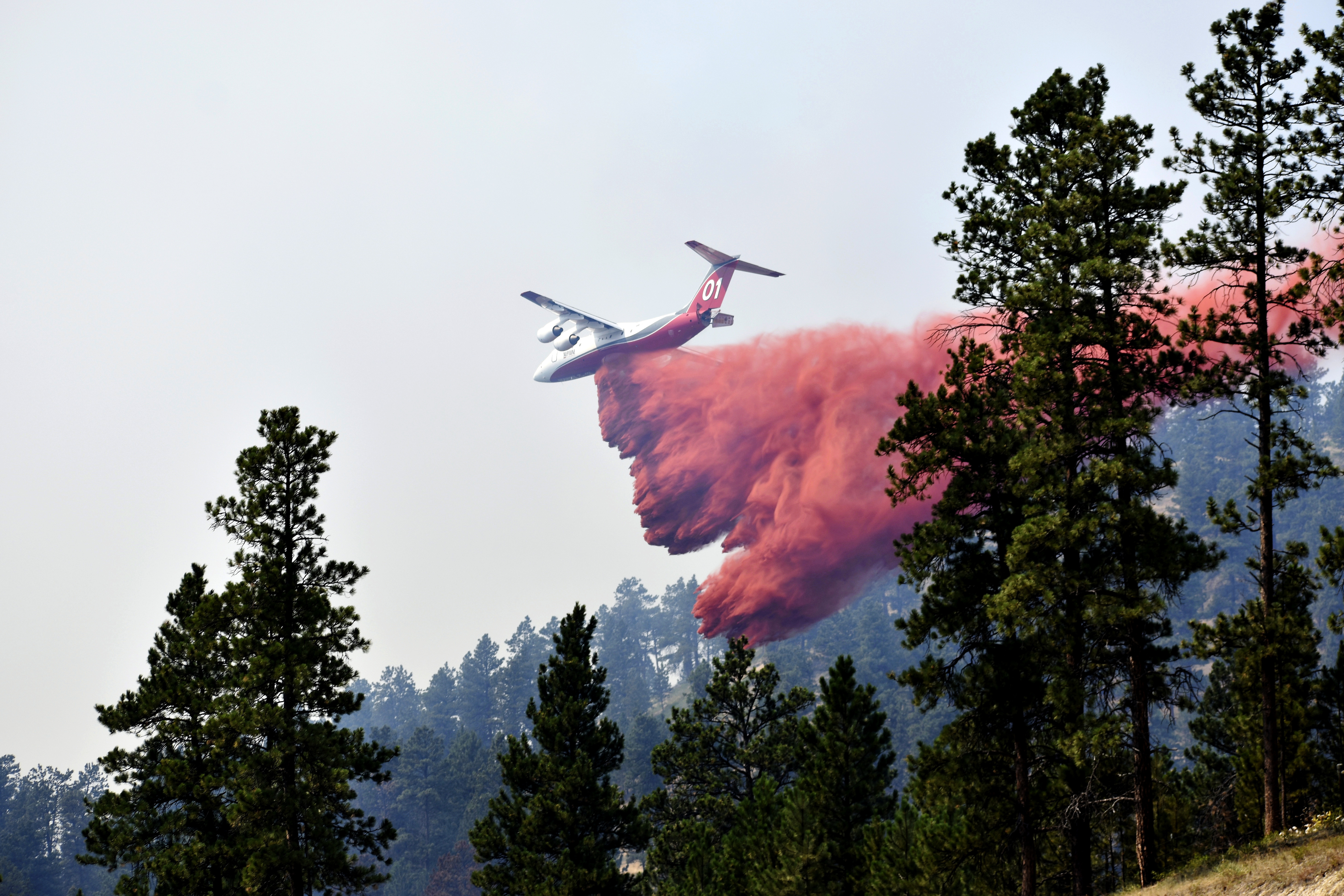 An aircraft drops fire retardant to slow the spread of the Richard Spring fire in Montana on Aug. 11, 2021. A legal dispute in Montana could drastically curb the government’s use of aerial fire retardant to combat wildfires.