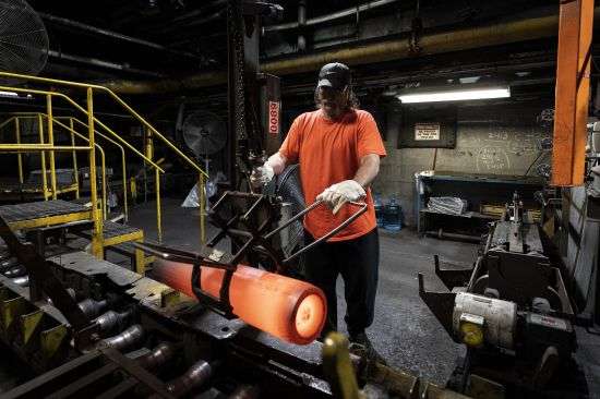A steel worker removes a heated 155 mm M795 artillery projectile for testing during the manufacturing process at the Scranton Army Ammunition Plant in Scranton, Pa., April 13. One of the most important munitions of the Ukraine war comes from a historic factory in this city built by coal barons, where tons of steel rods are brought in by train to be forged into the artillery shells Kyiv can’t get enough of — and that the U.S. can’t produce fast enough.