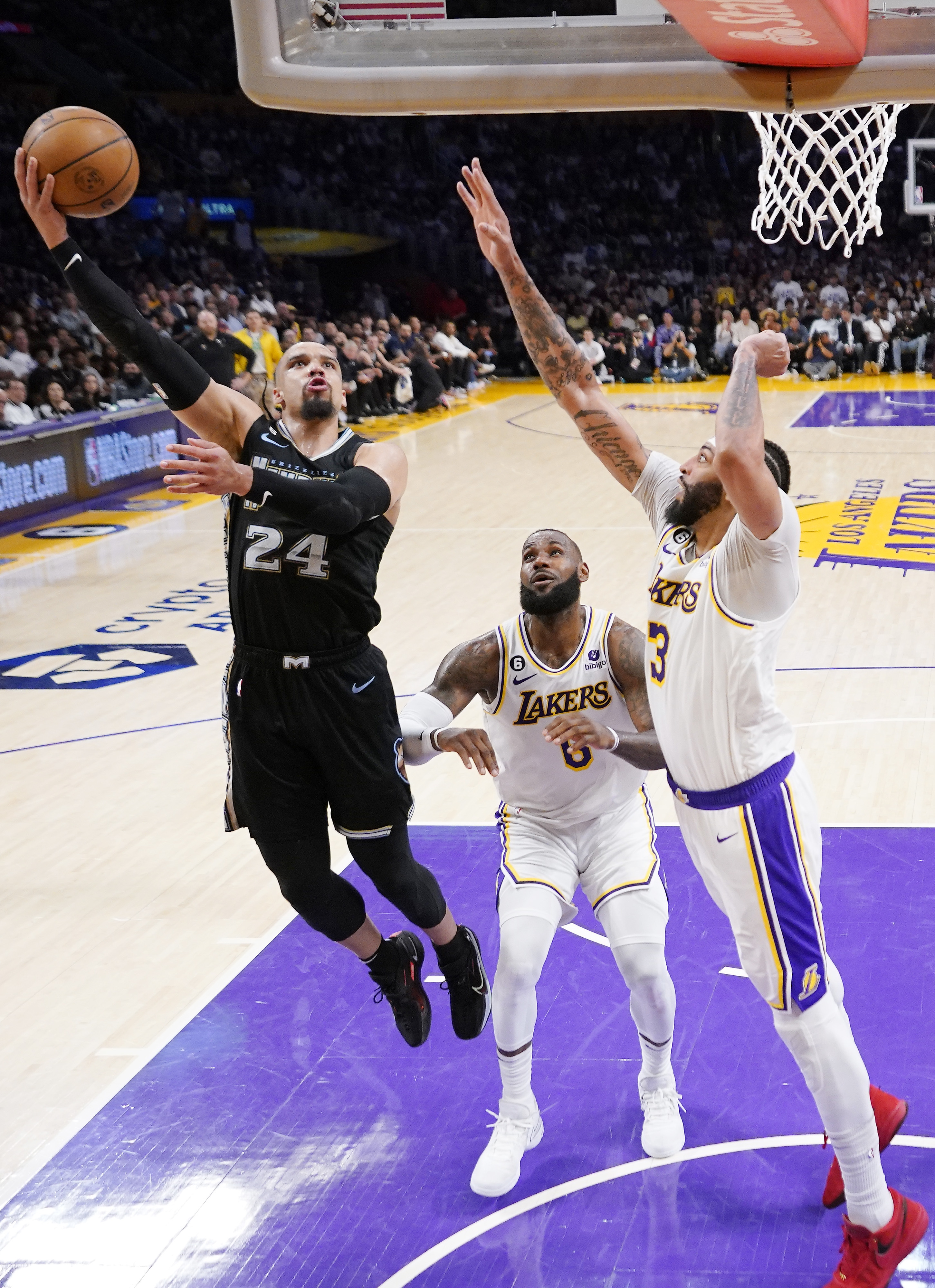 Memphis Grizzlies forward Dillon Brooks, left, shoots as Los Angeles Lakers forward LeBron James, center, and forward Anthony Davis defend during the first half in Game 3 of a first-round NBA basketball playoff series Saturday, April 22, 2023, in Los Angeles.