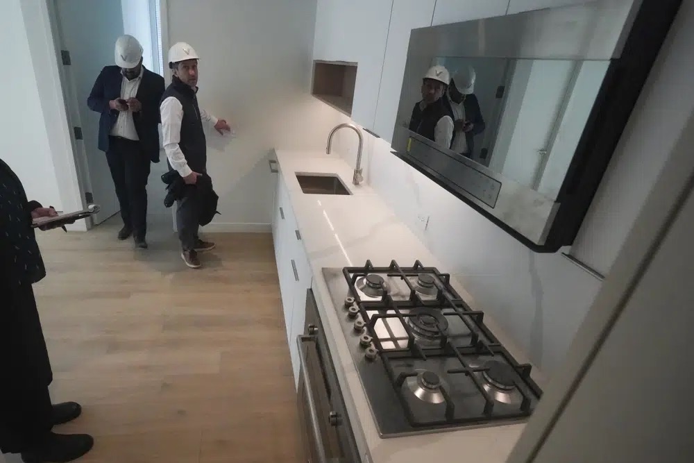 Joey Chilelli, right, managing director of real estate firm Vanbarton Group, and the company's senior project manager Malek Hajar, show the kitchen in a model apartment inside a high rise at 160 Water Street in Manhattan's financial district, undergoing conversion to residential apartments, April 11 in New York.