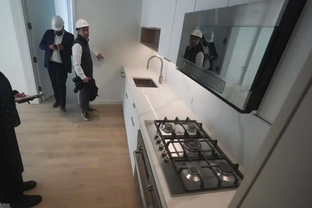 Joey Chilelli, right, managing director of real estate firm Vanbarton Group, and the company's senior project manager Malek Hajar, show the kitchen in a model apartment inside a high rise at 160 Water Street in Manhattan's financial district, undergoing conversion to residential apartments, April 11 in New York.