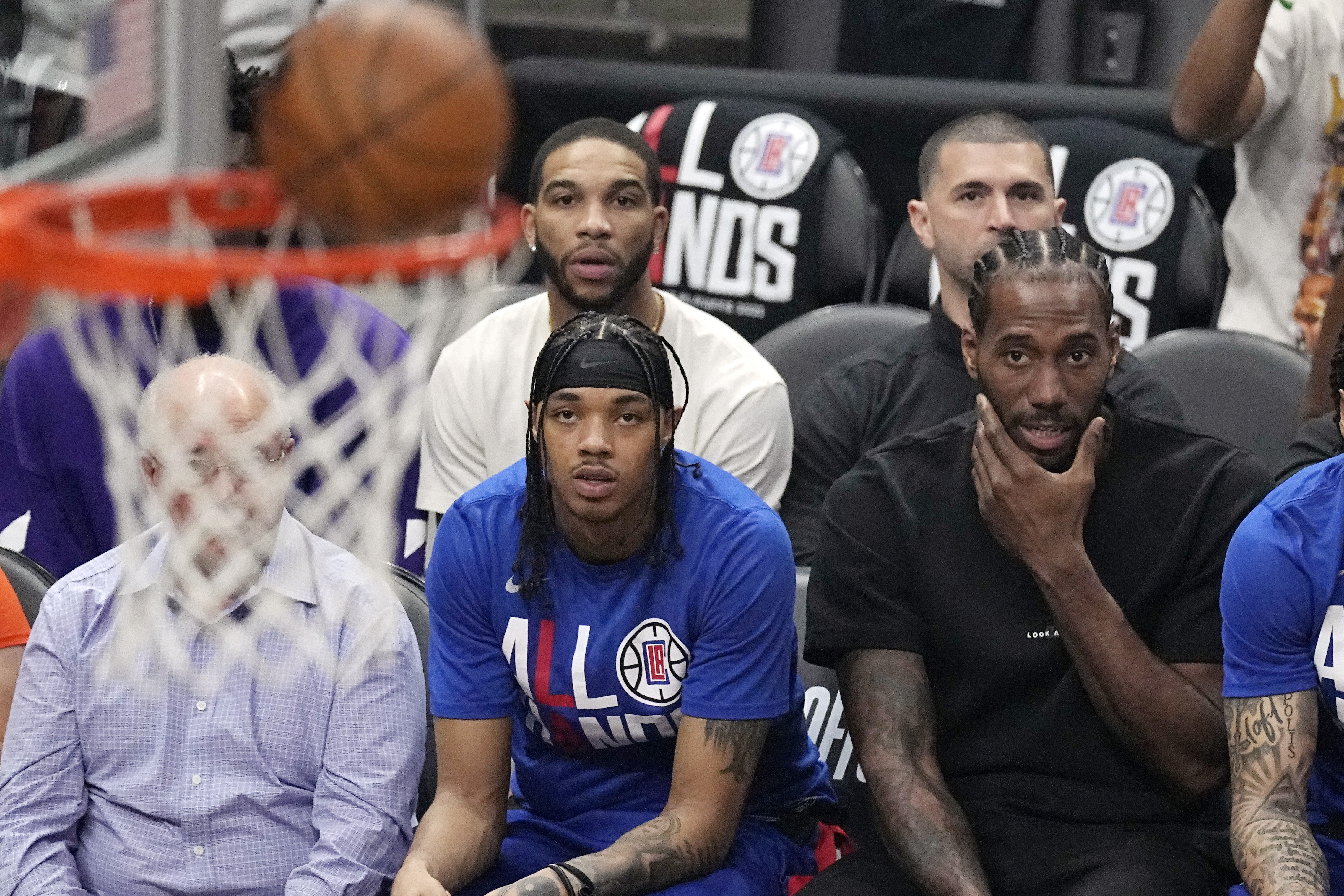 Los Angeles Clippers forward Kawhi Leonard, right, watches from the bench during the first half in Game 4 of a first-round NBA basketball playoff series against the Phoenix Suns Saturday, April 22, 2023, in Los Angeles. 