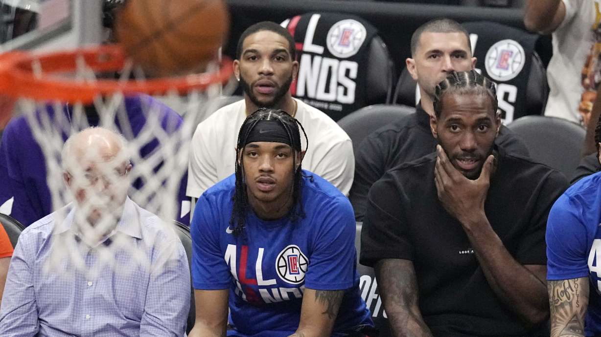 Los Angeles Clippers forward Kawhi Leonard, right, watches from the bench during the first half in Game 4 of a first-round NBA basketball playoff series against the Phoenix Suns Saturday, April 22, 2023, in Los Angeles.