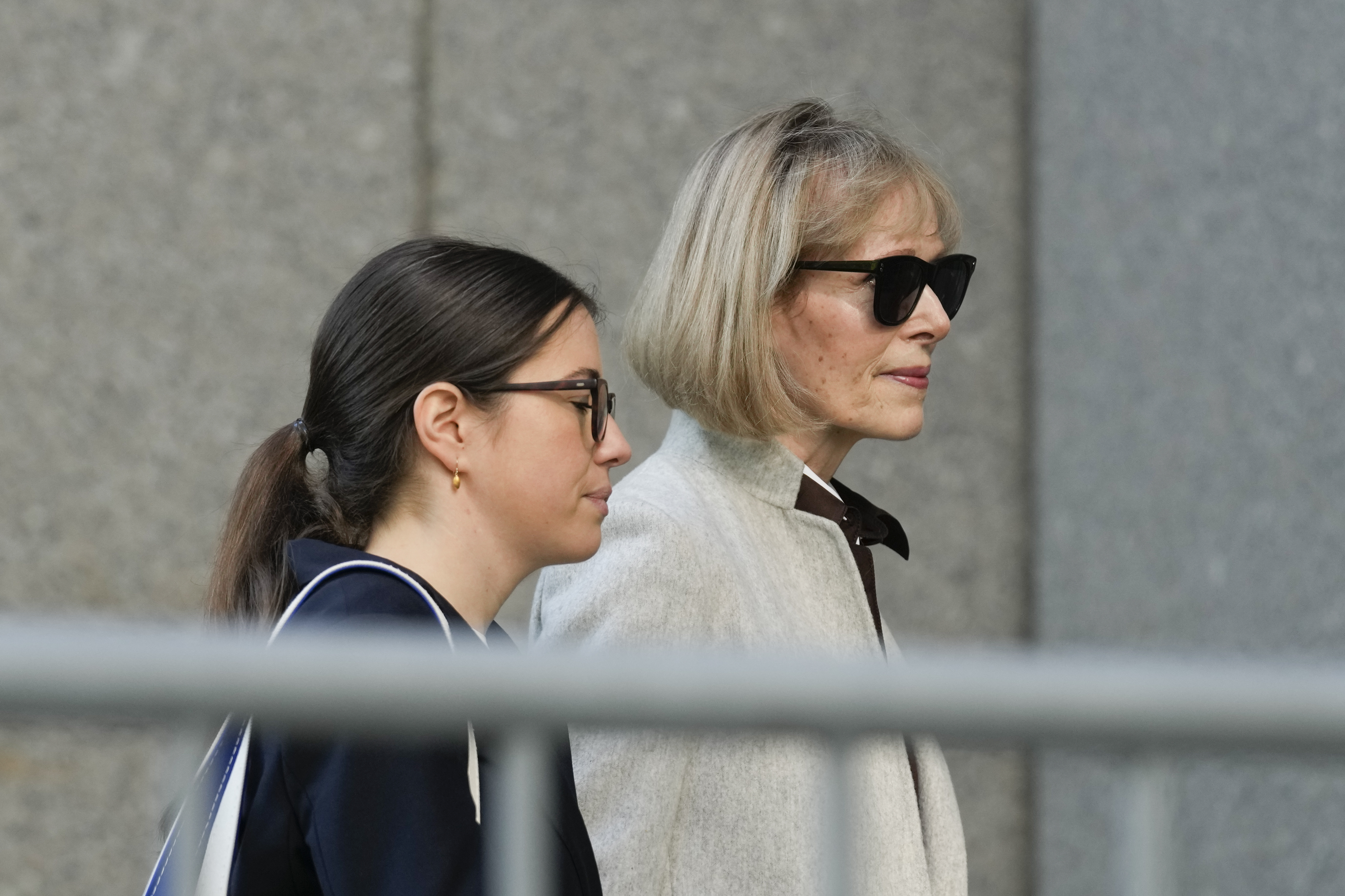 Former advice columnist E. Jean Carroll, right, walks into Manhattan federal court on Tuesday in New York. Jury selection is scheduled to begin in a trial over Carroll's claim that former President Donald Trump raped her nearly three decades ago in a department store dressing room.