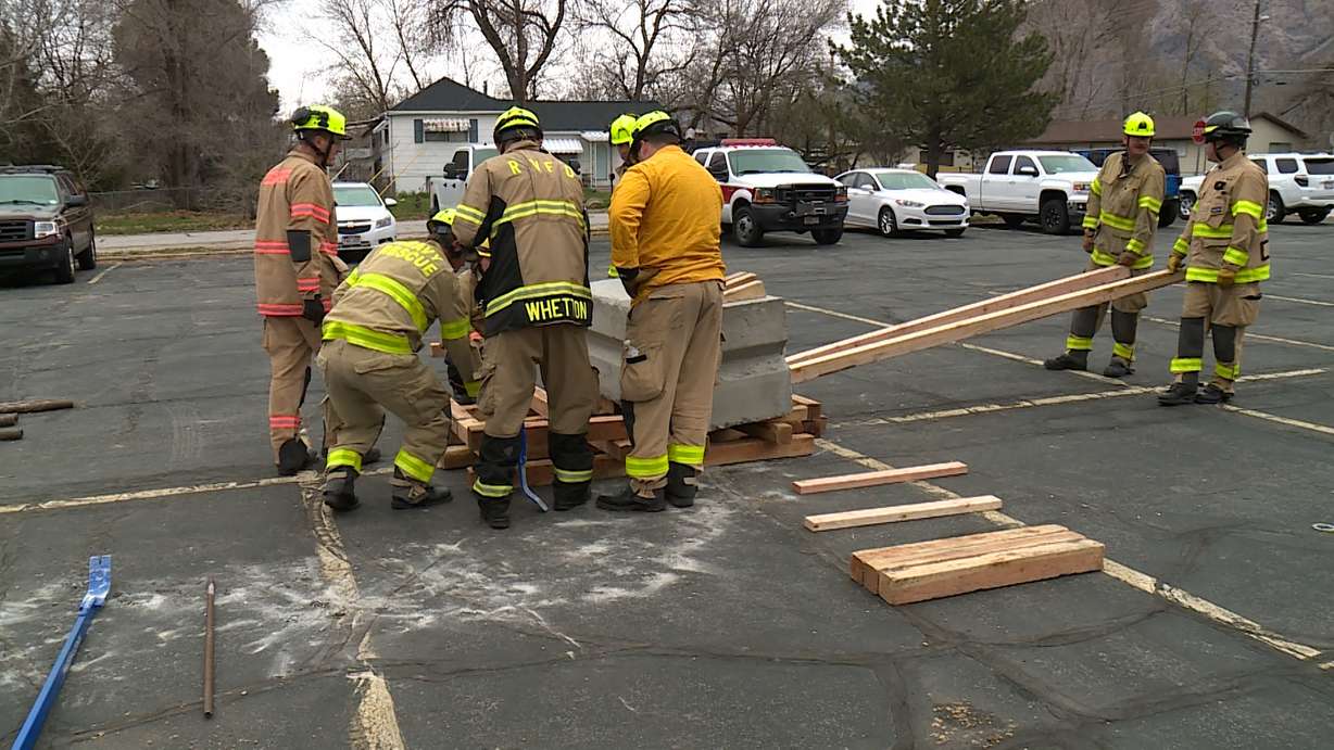 Firefighters practice removing a large chunk of debris during Tuesday's exercise.