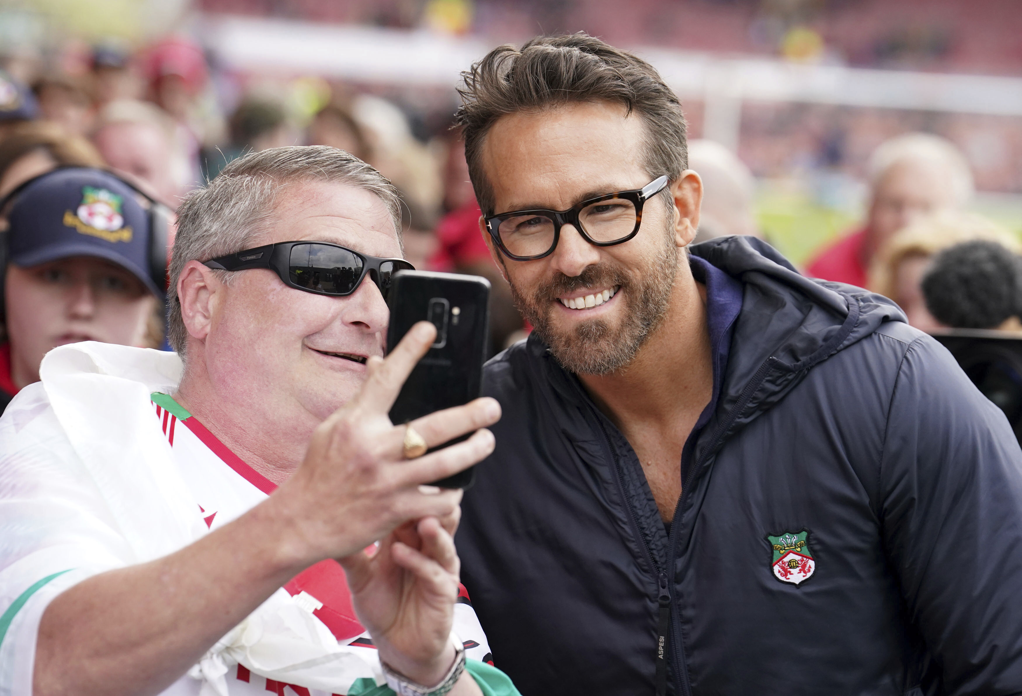 Wrexham co-owner Ryan Reynolds poses with fans ahead of the National League soccer match between Wrexham and Boreham Wood at The Racecourse Ground, in Wrexham, Wales, Saturday April 22, 2023. 