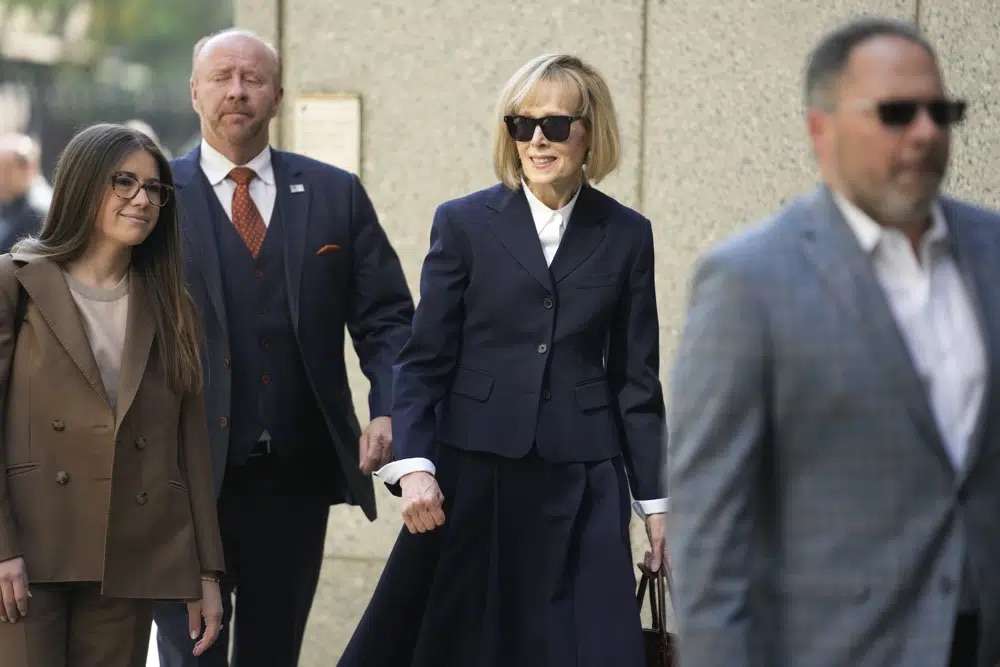 Former advice columnist E. Jean Carroll, second from right, arrives to federal court in New York, Wednesday. Jurors have been seated in the trial over Carroll's claim that former President Donald Trump raped her nearly three decades ago in a department store dressing room.