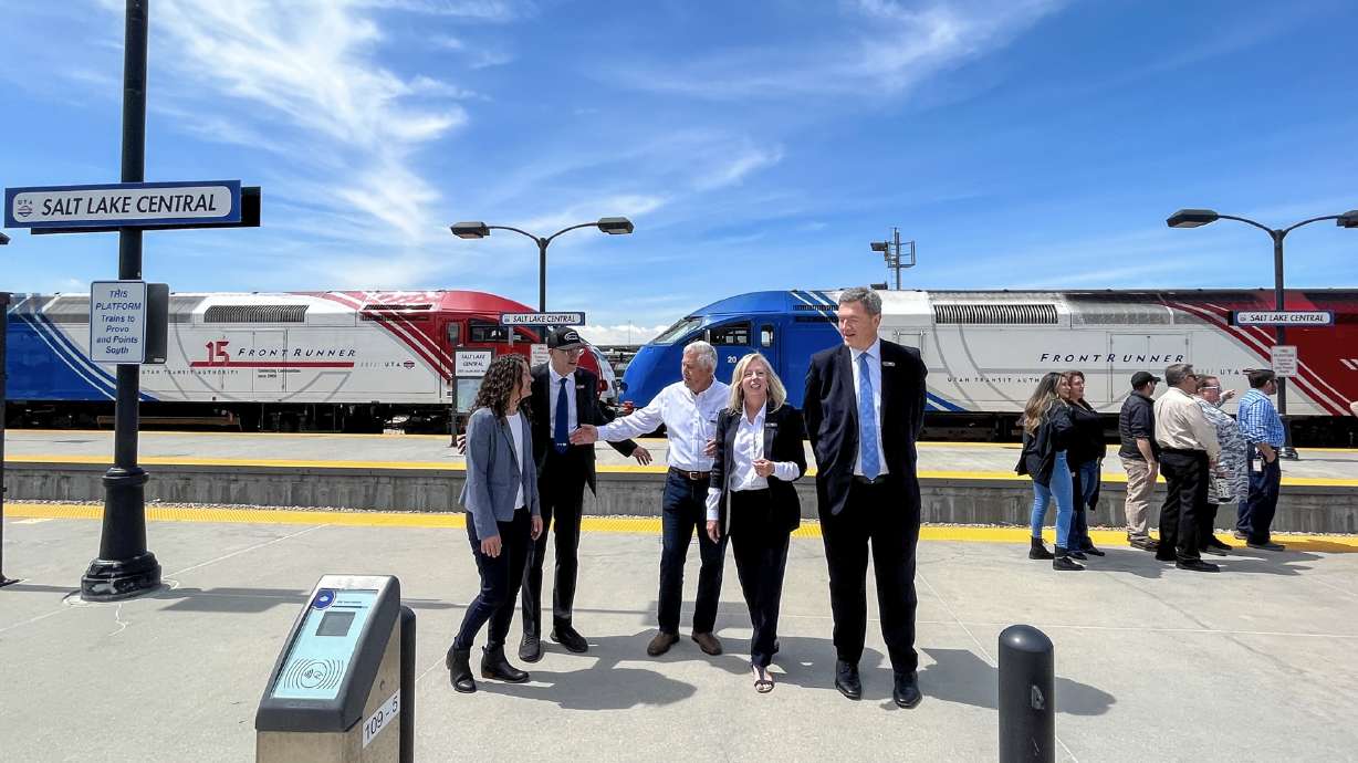 Utah Transit Authority Executive Director Jay Fox, second from left, and other UTA and UDOT officials with two parked FrontRunner trains at Salt Lake Central Station on Wednesday. UTA celebrated FrontRunner's 15th anniversary.
