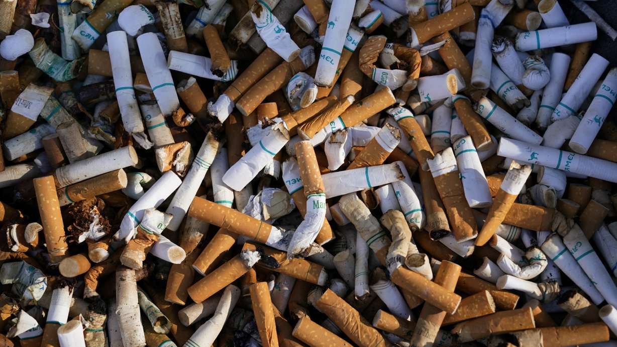 Cigarette butts fill a smoking receptacle outside a federal building in Washington, April 15, 2021. According to government survey data released Thursday, U.S. adults are smoking less.
