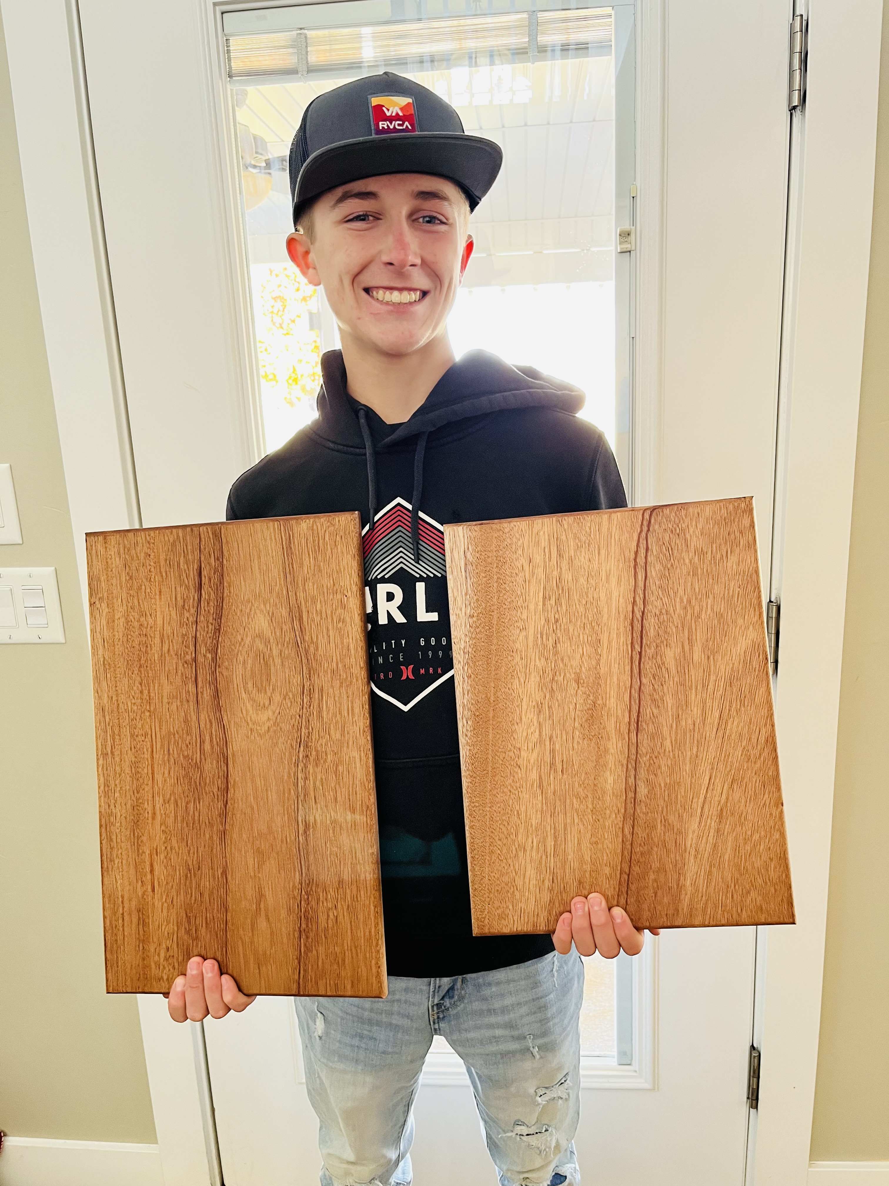 Mason Johnston holds cutting board he sells on Etsy.