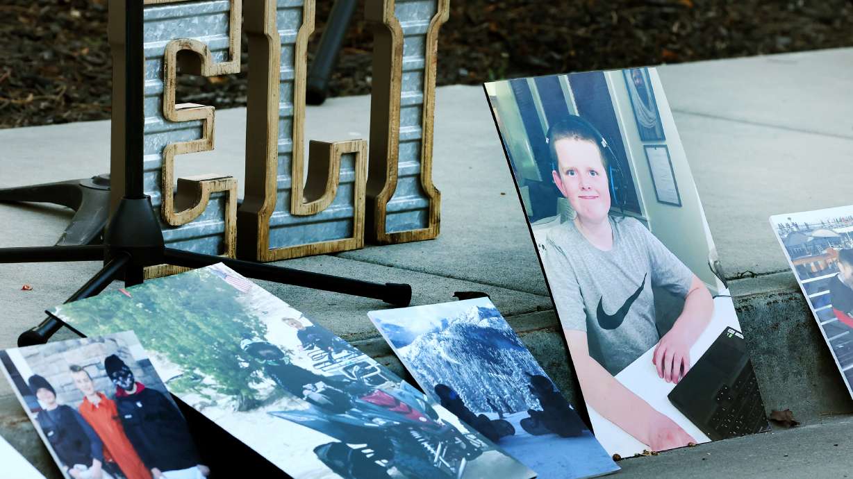 Photos and and a sign of Eli Mitchell's name sit on the sidewalk and gutter as people gathered Wednesday in West Jordan, at 9000 South and 1510 West. He was killed by a drunk driver one year ago.