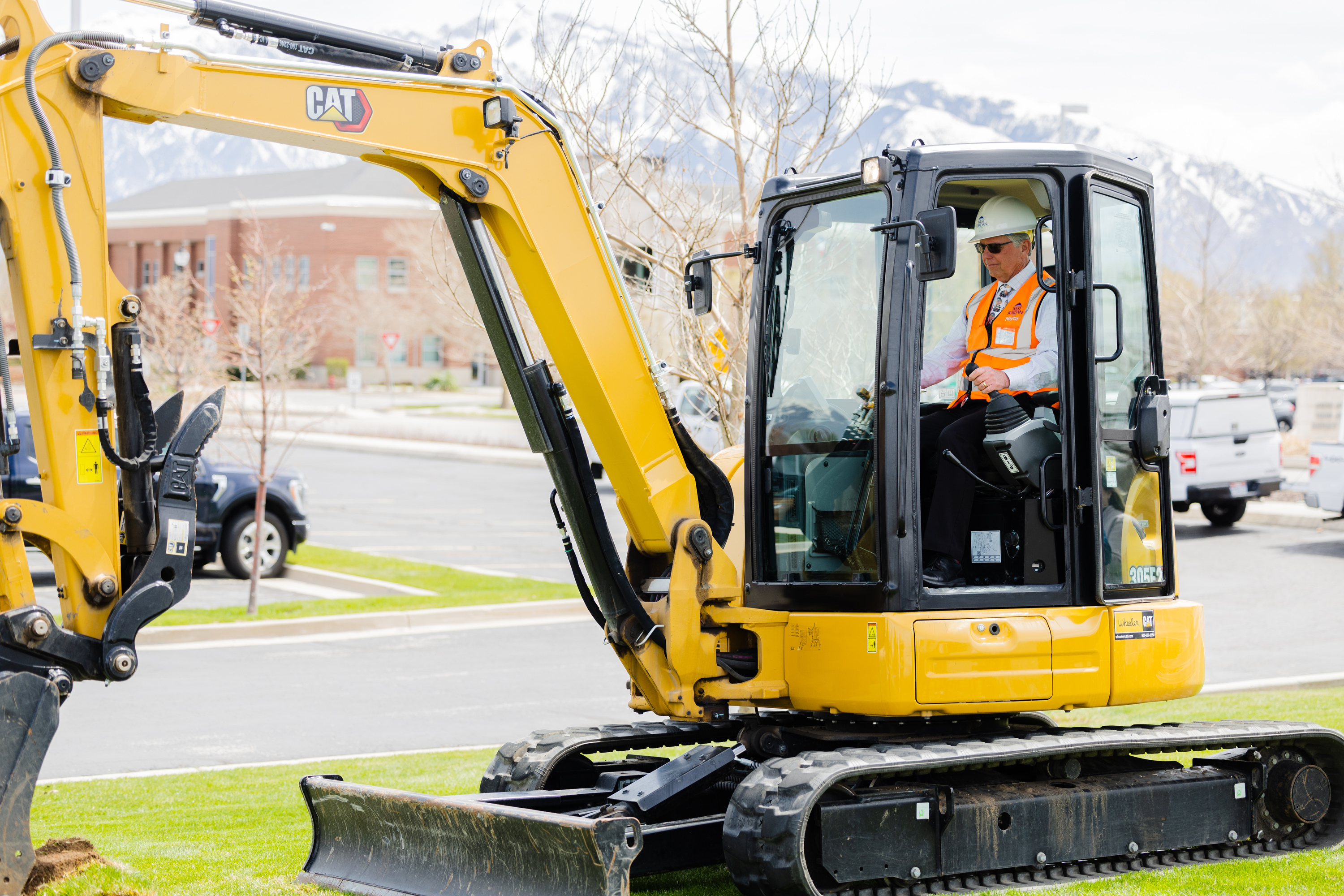 West Jordan Mayor Dirk Burton operates an excavator during a press conference announcing grants for the conversion of grass fields at the West Jordan City Hall on Thursday.