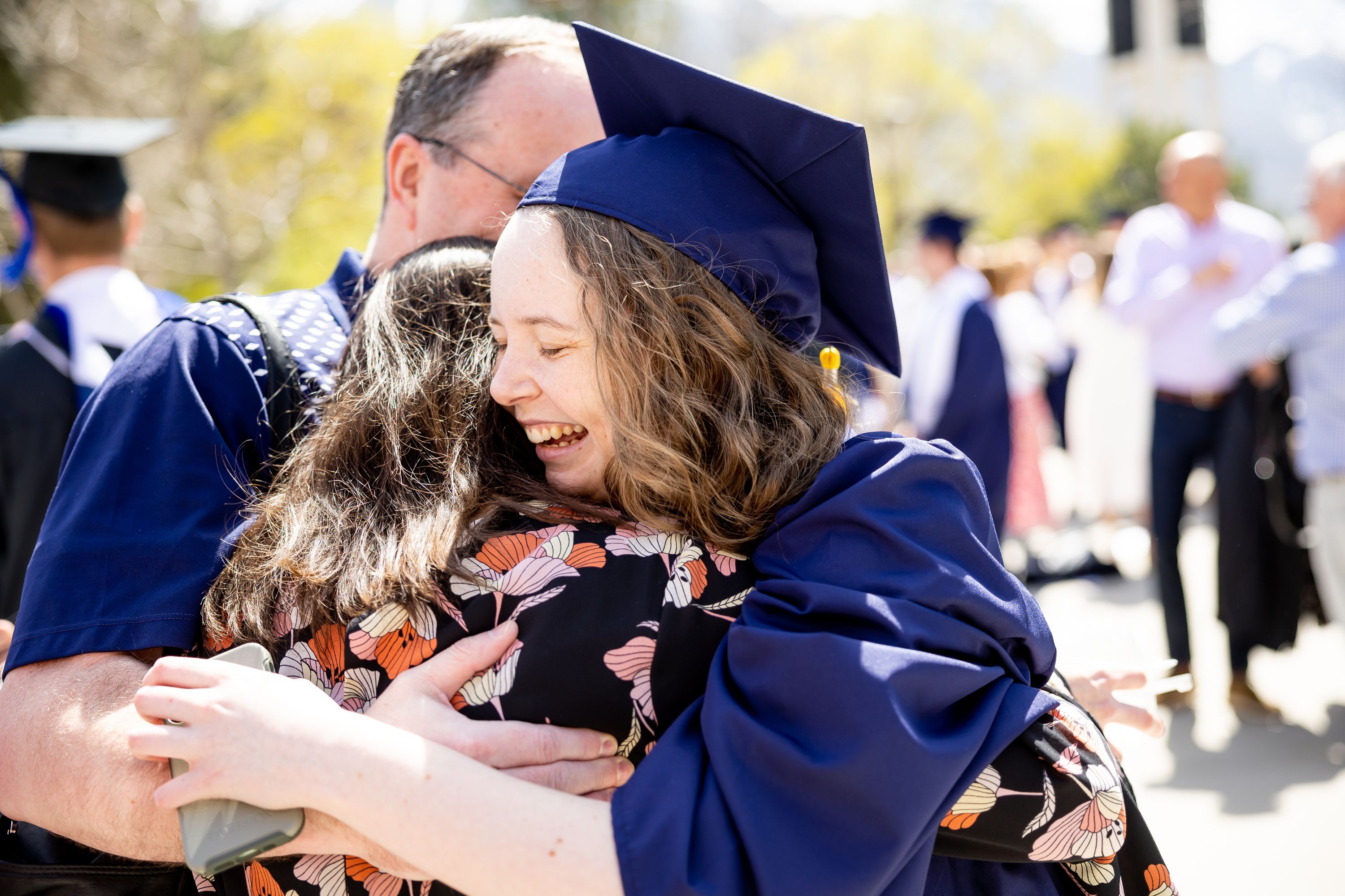 Graduate Kara Hunter, 21, of Boise, Idaho, embraces her parents, Stephanie and Ryan Hunter, after Brigham Young University’s commencement at the Marriott Center in Provo on Thursday.