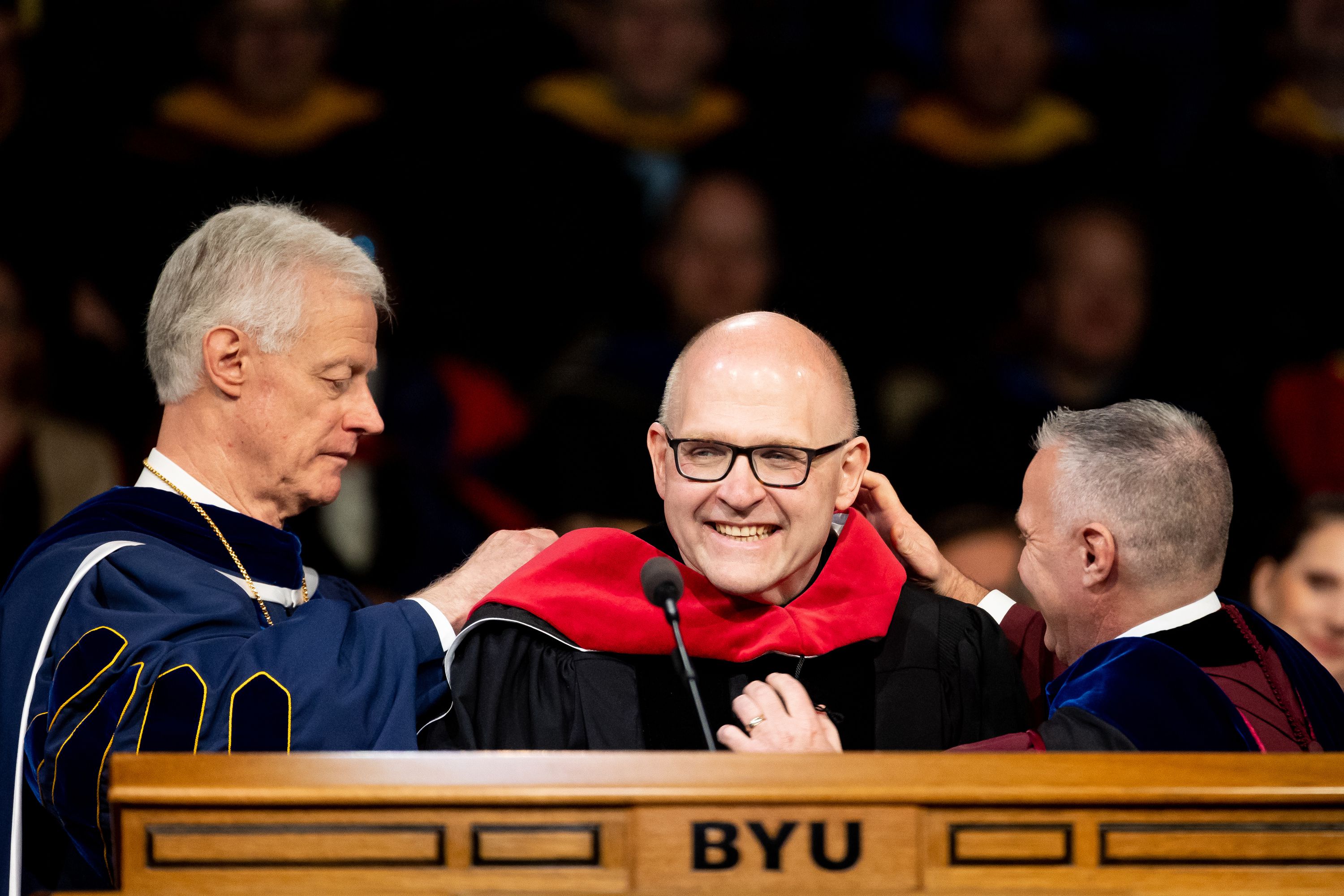 Rev. Dr. Andrew Teal has an honorary degree conferred upon him by Brigham Young University President Kevin J Worthen, left, and academic vice president C. Shane Reese during the university’s commencement at the Marriott Center in Provo on Thursday.