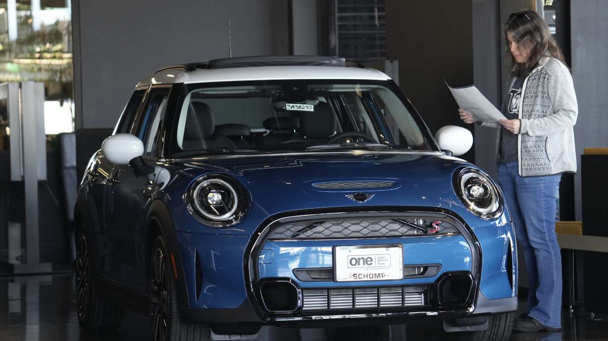 A potential buyer looks over an 2023 Cooper S sedan Feb. 17, in Highlands Ranch, Colo. On Friday, the Commerce Department issued its March report on consumer spending.