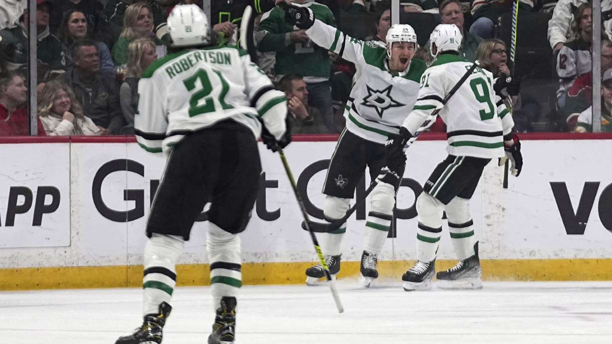 Dallas Stars center Roope Hintz, center, celebrates next to center Tyler Seguin, right, after scoring during the first period of Game 6 of an NHL hockey Stanley Cup first-round playoff series against the Minnesota Wild, Friday, April 28, 2023, in St. Paul, Minn.