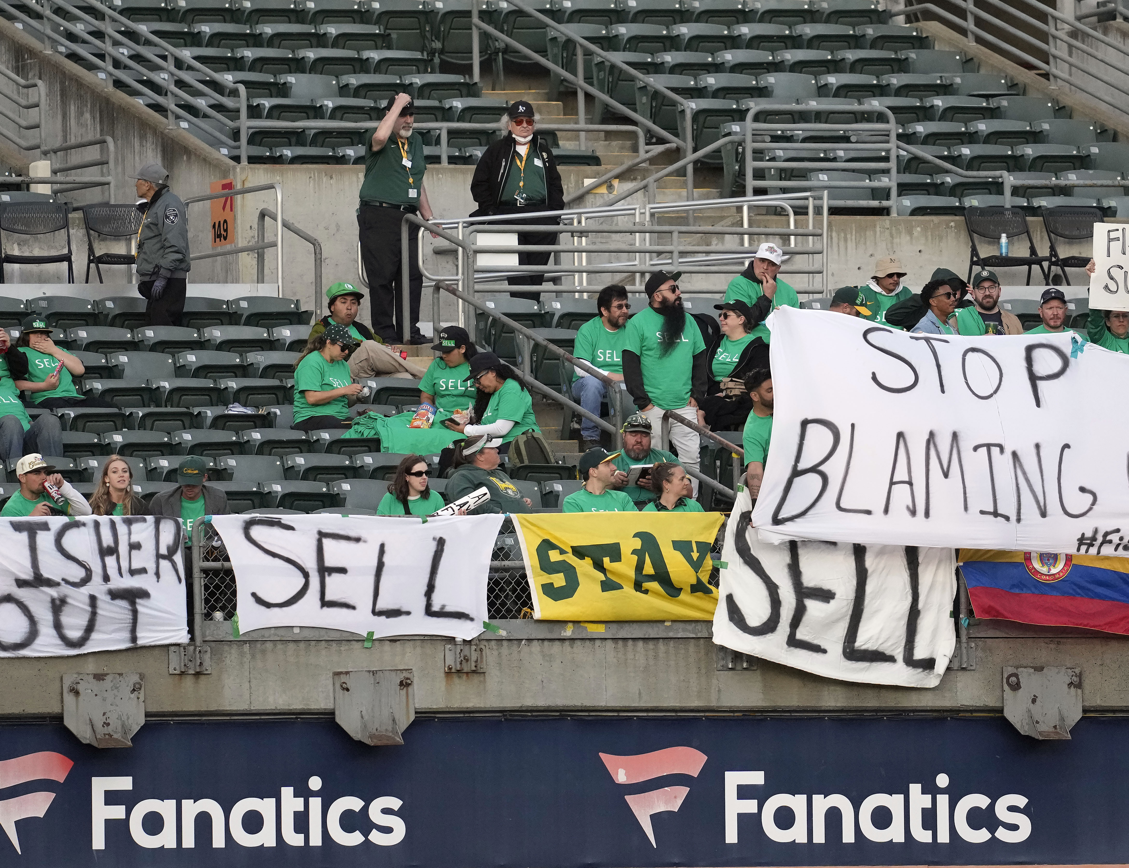 Oakland Athletics fans hang signs at RingCentral Coliseum to protest the team's potential move to Las Vegas and to call for team owner John Fisher to sell the team during a baseball game between the Athletics and the Cincinnati Reds in Oakland, Calif., Friday, April 28, 2023.