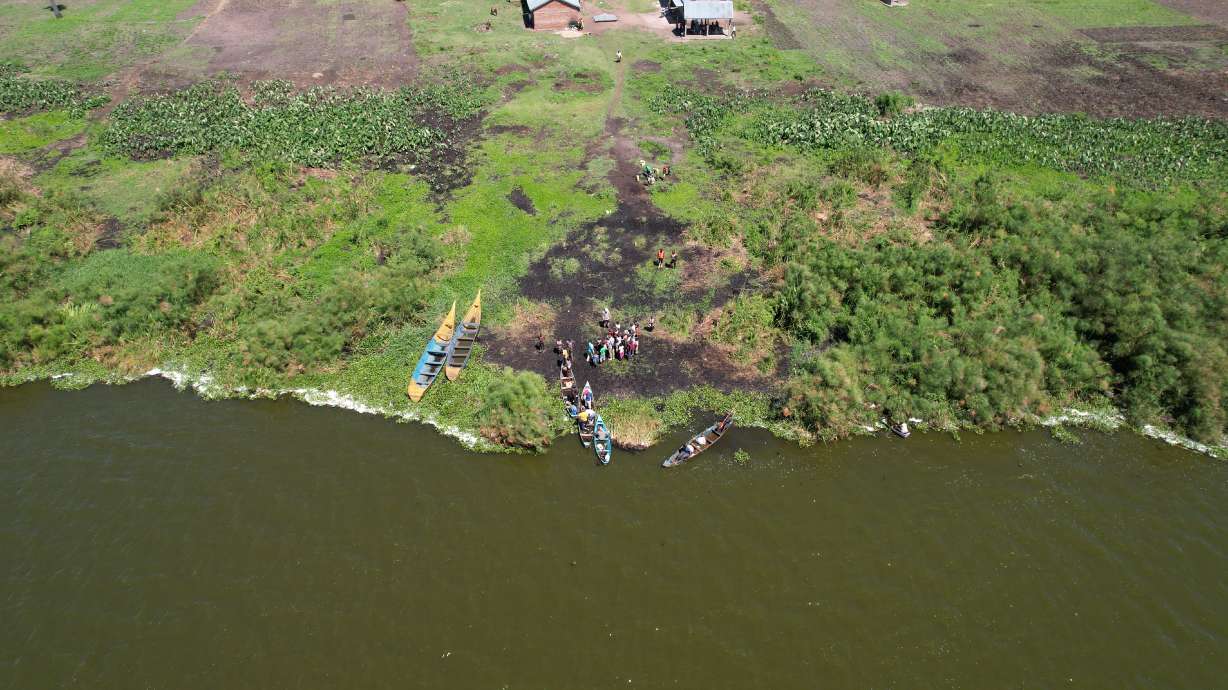 People get into canoes on the shore of Lake Nakuwa in Uganda in April 2023. The lake used to be infested with an invasive weed, but thanks to a small beetle, the lake is clean.