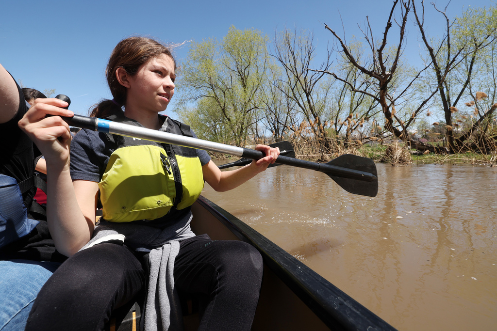 Arianna Kimball studies the shoreline as she and other kids from the Evergreen after school program get to ride in canoes on the Jordan River in Salt Lake City Friday. 
