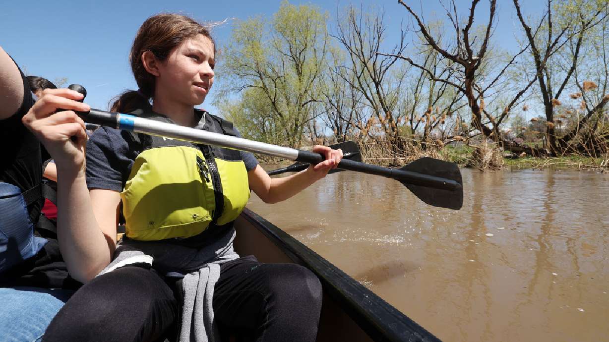 Arianna Kimball studies the shoreline as she and other kids from the Evergreen after school program get to ride in canoes on the Jordan River in Salt Lake City Friday.