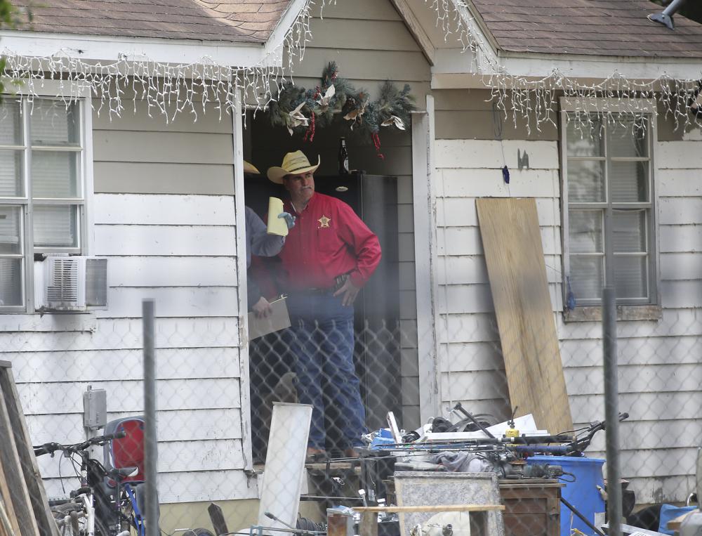 San Jacinto County Sheriff Greg Capers talks to investigators at the scene where five people were shot and killed the night before, Saturday in unincorporated San Jacinto County, Texas. The suspect, Francisco Oropeza, who lives next door, is still at large. 