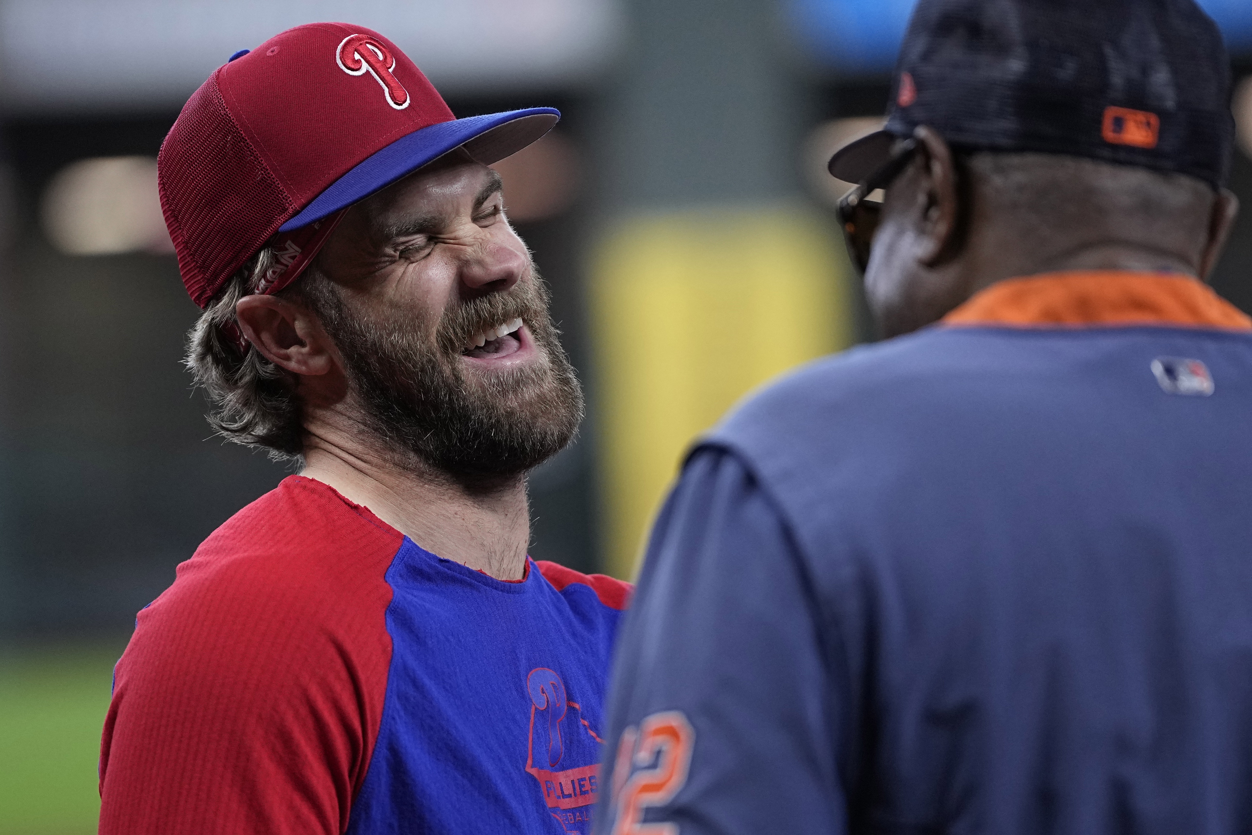 Philadelphia Phillies' Bryce Harper, left, laughs with talking with Houston Astros manager Dusty Baker Jr. before a baseball game Saturday, April 29, 2023, in Houston.