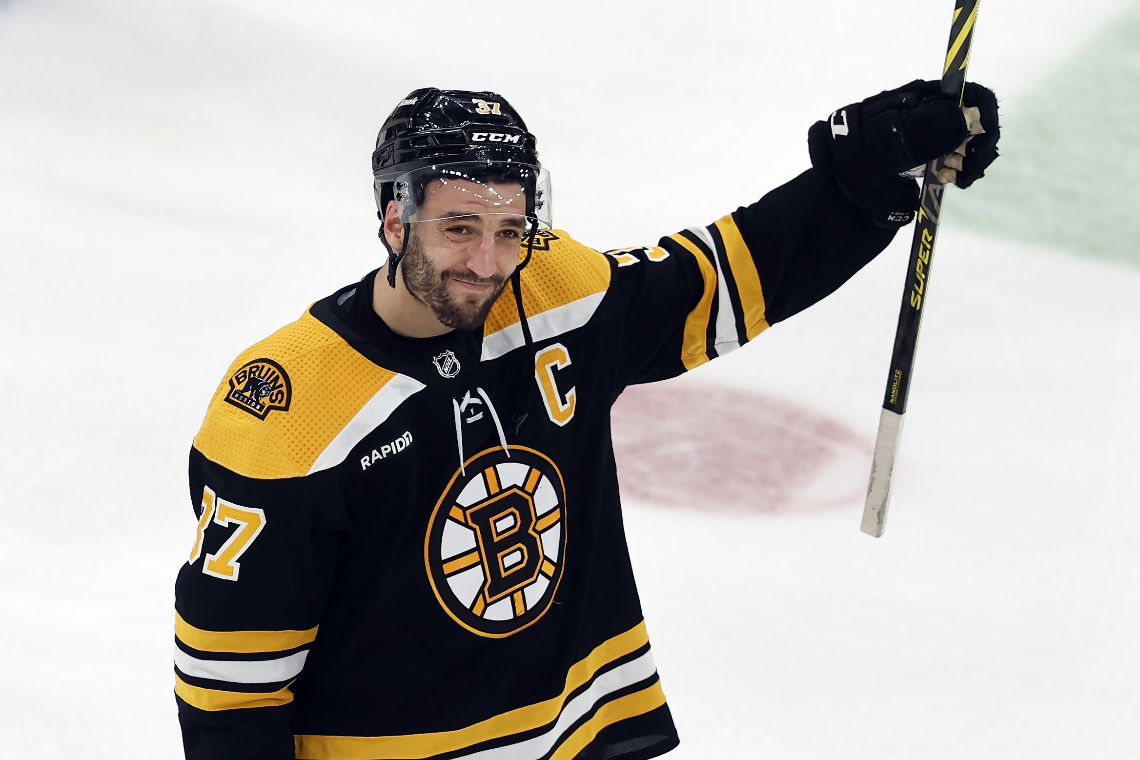 Boston Bruins' Patrice Bergeron raises his stick to the fans after losing to the Florida Panthers in overtime during Game 7 of an NHL hockey Stanley Cup first-round playoff series, Sunday, April 30, 2023, in Boston. 