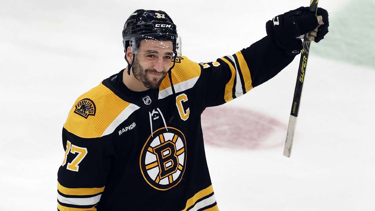 Boston Bruins' Patrice Bergeron raises his stick to the fans after losing to the Florida Panthers in overtime during Game 7 of an NHL hockey Stanley Cup first-round playoff series, Sunday, April 30, 2023, in Boston.