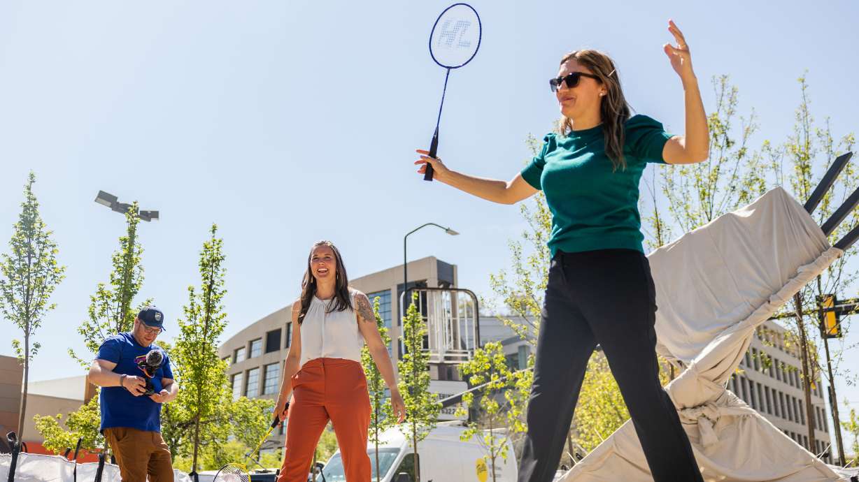 Salt Lake City Mayor Erin Mendenhall, center, and Salt Lake City Council member Ana Valderomos, right, play badminton during the unveiling of the “Green Loop,” a temporary public park at 200 East 300 South in downtown Salt Lake City on Monday.