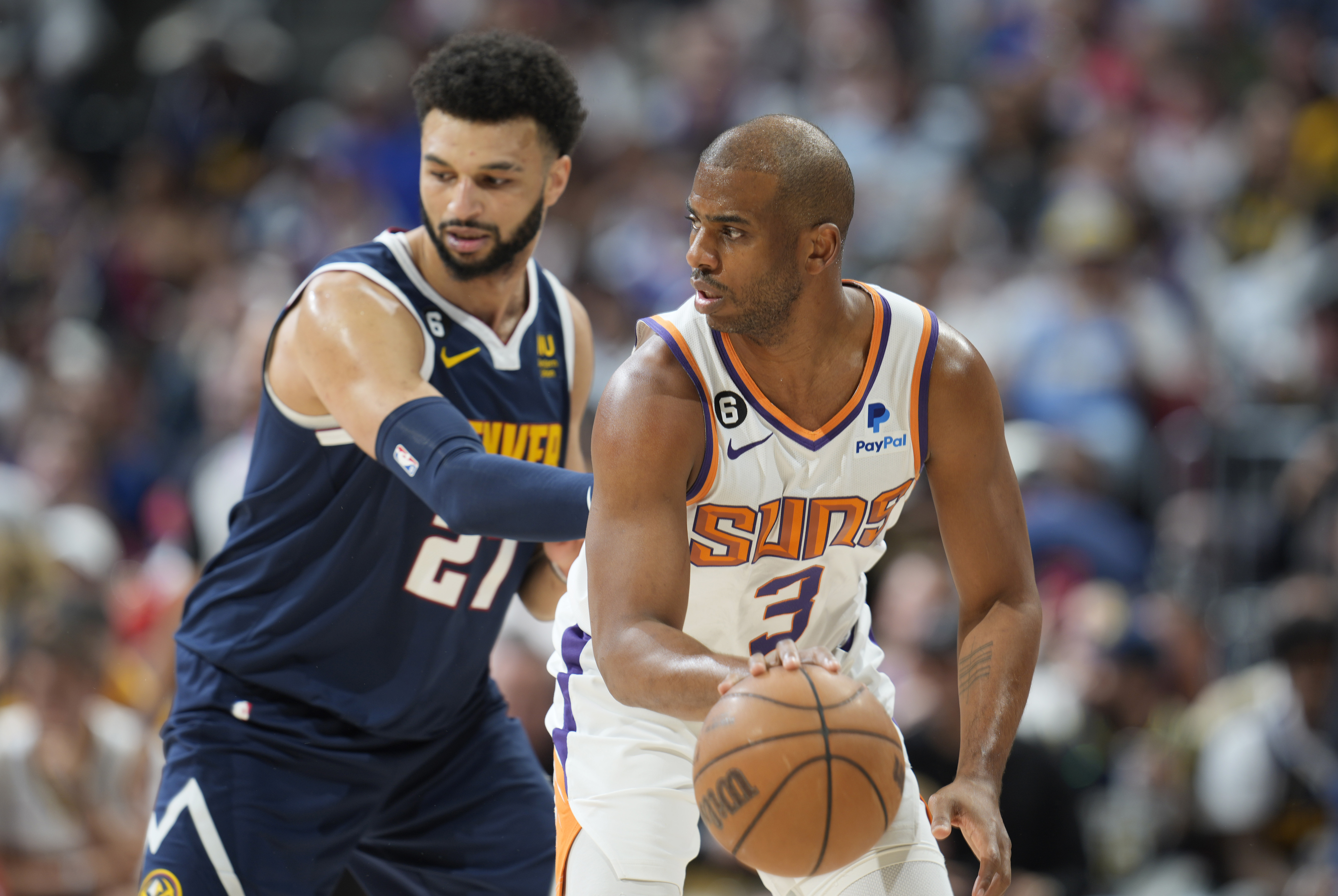 Phoenix Suns guard Chris Paul, right, looks to pass the ball as Denver Nuggets guard Jamal Murray, left, defends in the first half of Game 2 of an NBA second-round playoff series Monday, May 1, 2023, in Denver. 