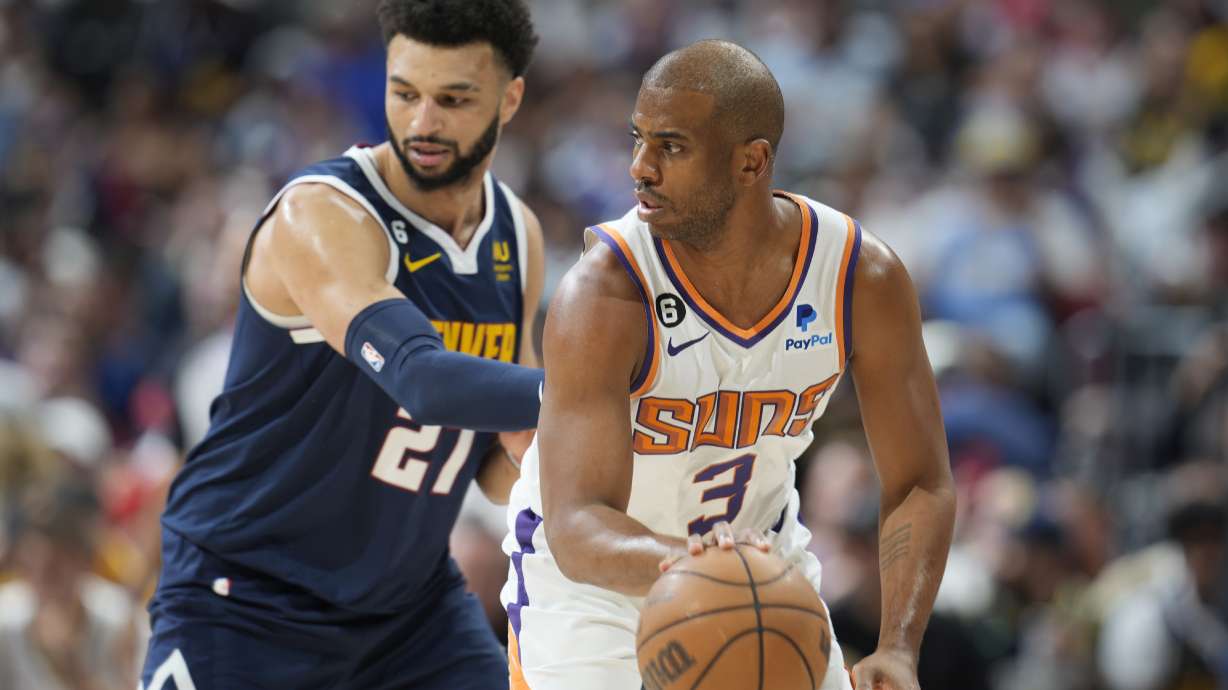 Phoenix Suns guard Chris Paul, right, looks to pass the ball as Denver Nuggets guard Jamal Murray, left, defends in the first half of Game 2 of an NBA second-round playoff series Monday, May 1, 2023, in Denver.