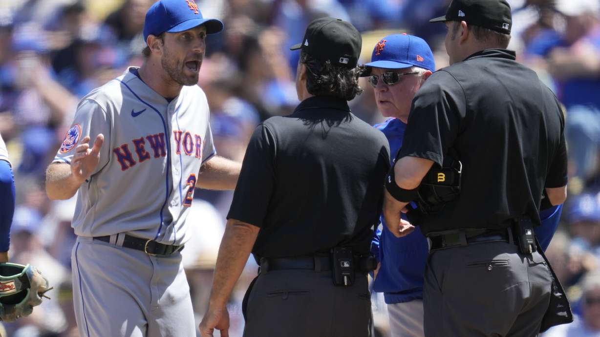 New York Mets starting pitcher Max Scherzer (21) and manager Buck Showalter dispute a call from umpire Phil Cuzzi, center, and umpire Dan Bellino, right, after they found a problem with Scherzer's glove during the fourth inning of a baseball game in Los Angeles, Wednesday, April 19, 2023. Scherzer was ejected from the game.