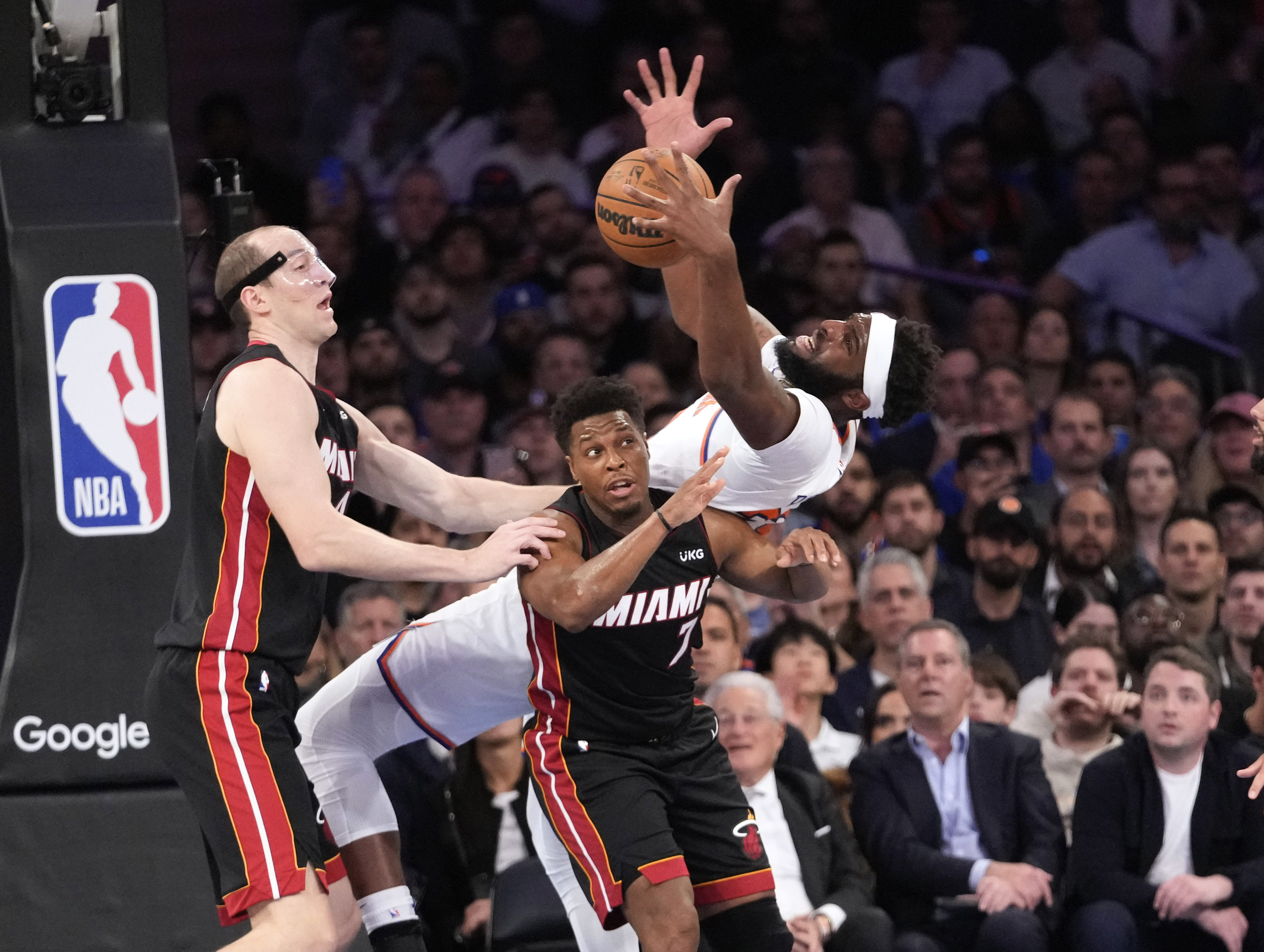 Miami Heat center Cody Zeller, left, watches New York Knicks center Mitchell Robinson fall over Miami Heat guard Kyle Lowry (7) while fighting for a rebound in the first half of Game 2 in the NBA basketball Eastern Conference semifinals playoff series, Tuesday, May 2, 2023, at Madison Square Garden in New York. 