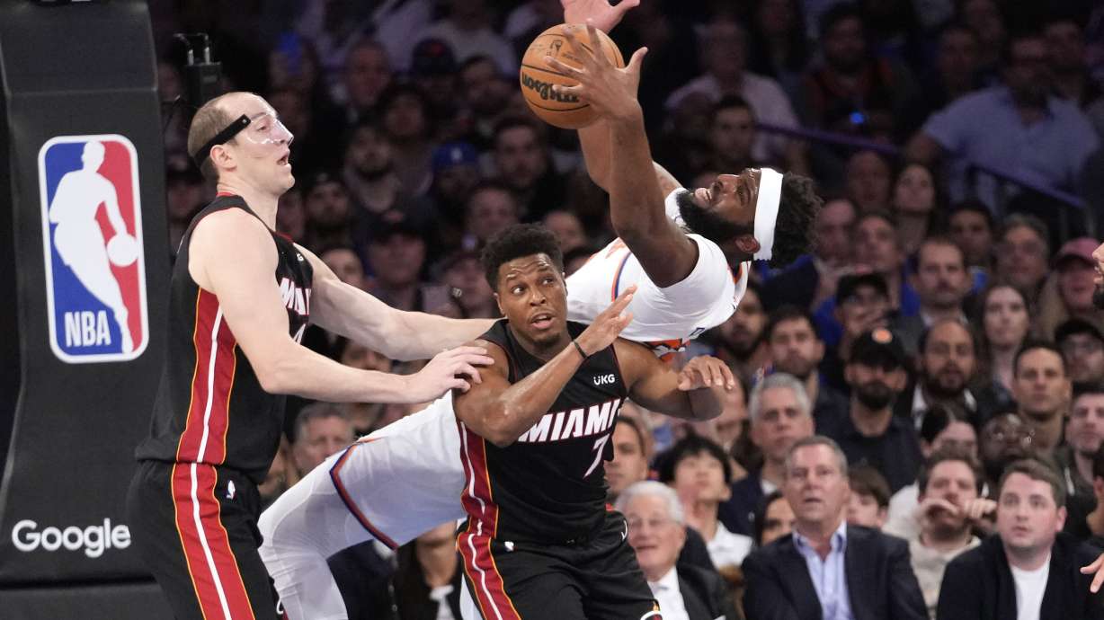 Miami Heat center Cody Zeller, left, watches New York Knicks center Mitchell Robinson fall over Miami Heat guard Kyle Lowry (7) while fighting for a rebound in the first half of Game 2 in the NBA basketball Eastern Conference semifinals playoff series, Tuesday, May 2, 2023, at Madison Square Garden in New York.