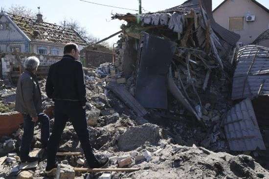 People look at a building destroyed by Russian shelling at night in Zaporizhia, Ukraine, Wednesday.