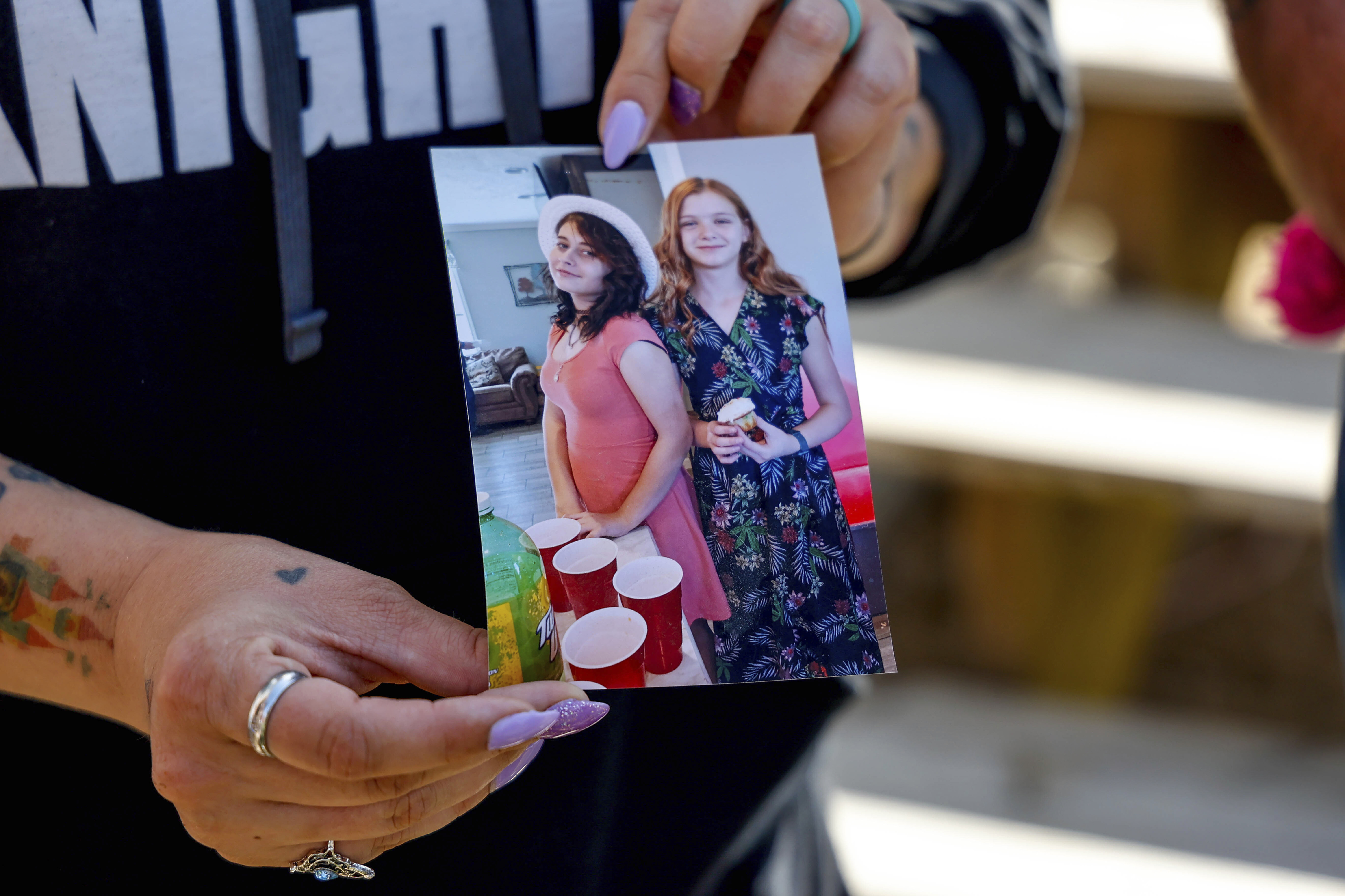 Ashleigh Webster shows a photo of Ivy Webster and Tiffany Guess at her home in Henryetta, Okla., Tuesday. An Oklahoma sex offender shot his wife, her three children and their two friends then killed himself, authorities confirmed Wednesday.