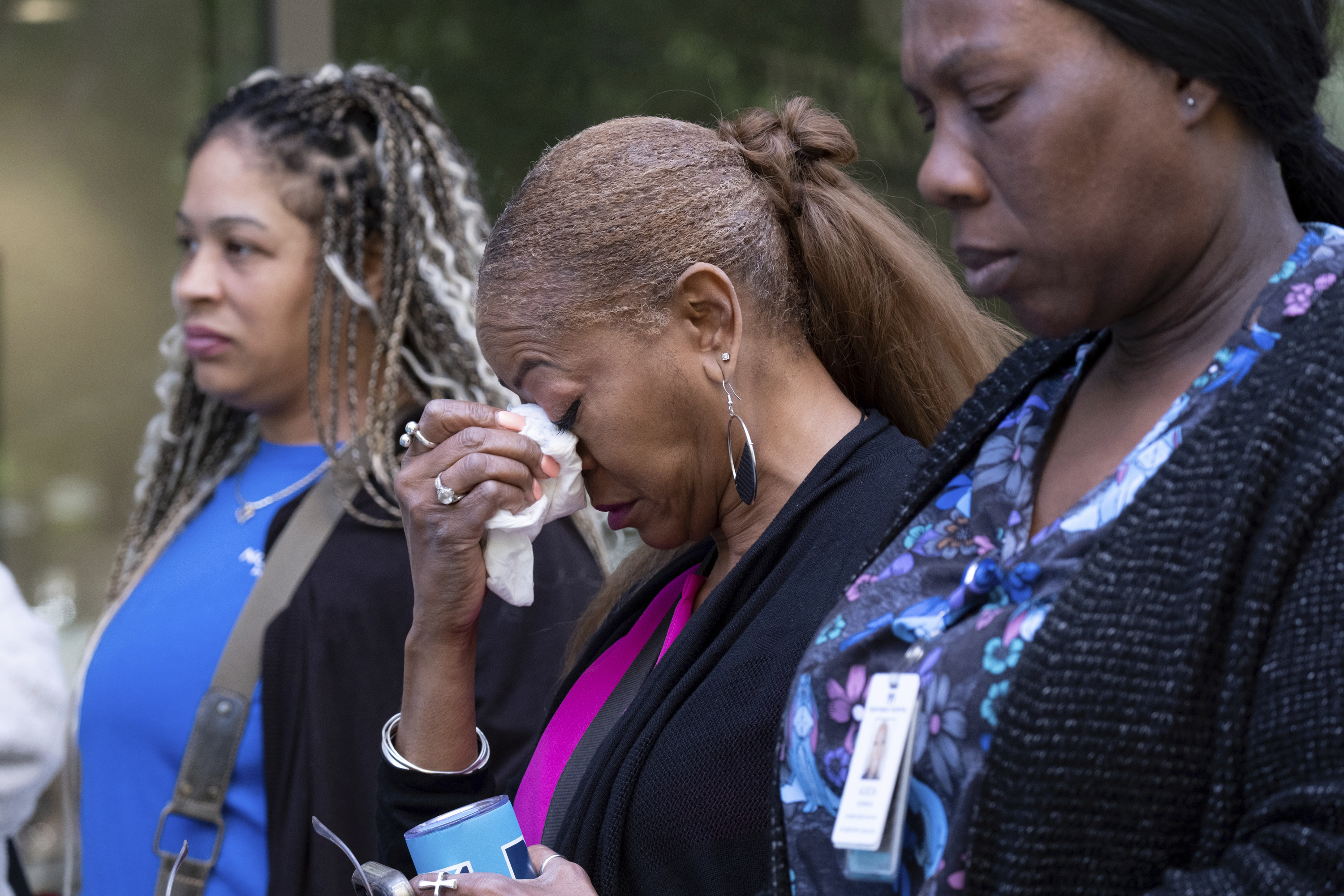 A woman tears up after evacuating following a shooting at a medical building in Midtown Atlanta on Wednesday. Police say they have apprehended a man who allegedly opened fire inside the waiting room of the medical facility, killing one woman and injuring four others.